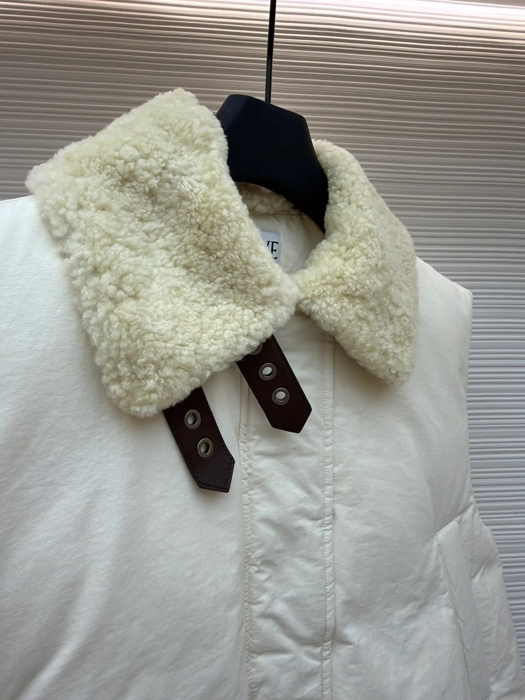 LOEWE lamb collar stitching tie decorative vest ●Original version: Purchased and developed in 20277 ●Item number: 1680964-E65 ●Fabric: Sheepskin lamb fabric ●Technology: embroidery production ●Version: Fitted version ●Weight: about 1005 grams ●Size: S-M-L ●Description: Made of Oxford fabric blended with 60% cotton and 40% nylon. Cotton fiber has a natural skin-friendly feel and good moisture absorption and breathability. The addition of nylon improves wear resistance and skeleton strength, while the high-density braid layer enhances the velvet locking effect. The lambswool lapel design effectively wraps the neck and reduces heat loss. Its texture is soft, delicate to the touch, close to the skin and non-irritating, providing a comfortable experience. The furry texture can modify facial lines, making the face look smaller and more refined. It uses 90 white duck down with a weight of 220g to ensure excellent thermal insulation performance. After strict screening and processing, the velvet is not easy to get drilled, ensuring durability. The inner and outer denim fabrics are misaligned by 1.5 cm, blocking the migration path of velvet. The anti-velvet silk thread is used through the imported No. 7 needle to achieve a chain stitch of 14 stitches/inch, resulting in tight and straight stitch spacing and a sewing effect without skipping stitches. The inner bag surface is formed into high-precision Anagram embroidery with about 6,000 stitches through the advanced computer control system and precision mechanical components of the imported embroidery machine. The overall wiring is straight and delicate, the fabric is comfortable and soft, and the color is consistent without color difference. It can be matched with the same style to create a fashionable look and control various occasions. Customized accessories, complete with three standards, same style for men and women!