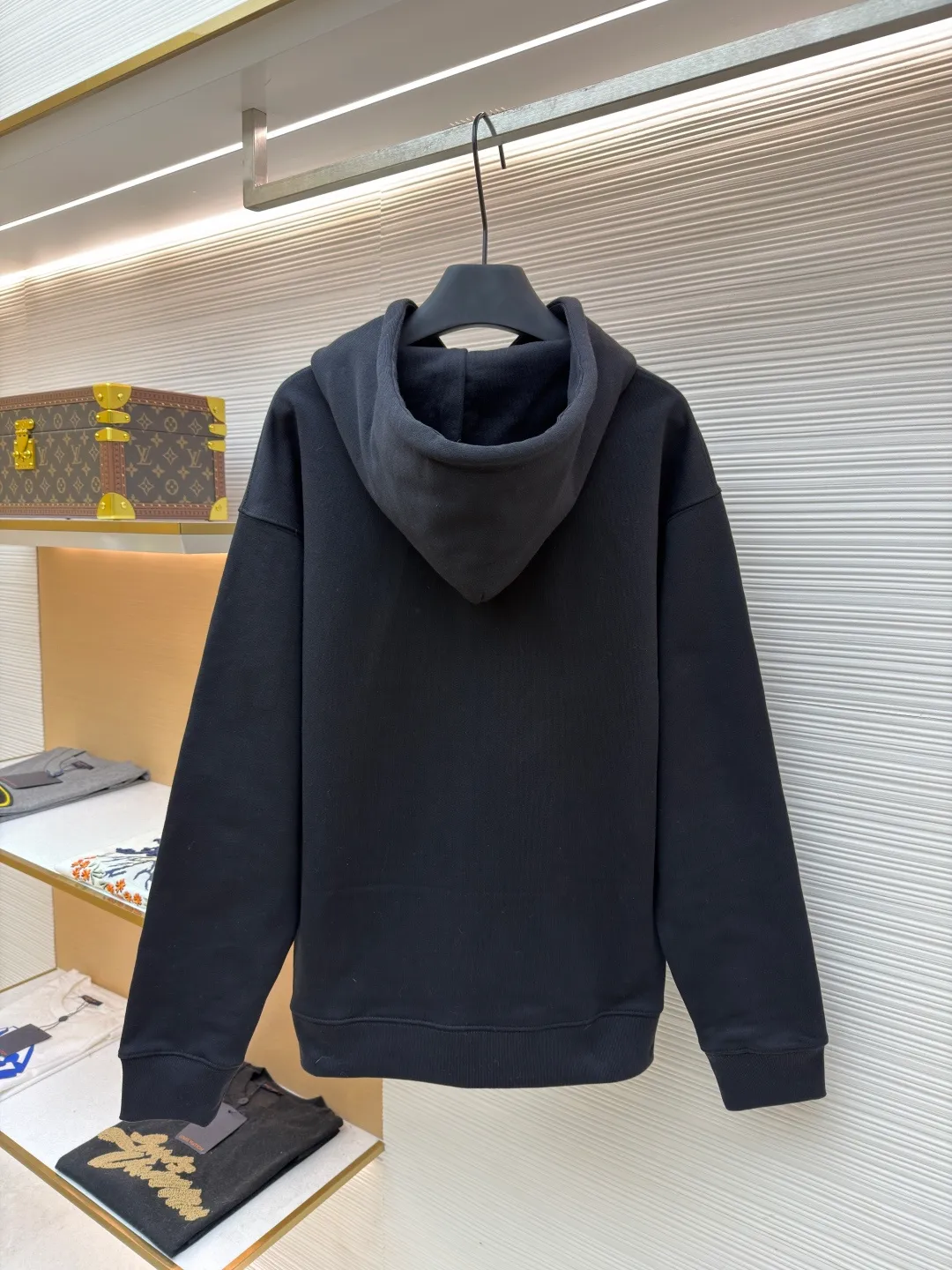 Loewe quirky kitten embossed hooded sweatshirt ●Original version: Purchased and developed by 8718 ●Item number: 1681954-A85 ●Material: pure cotton fabric ●Technology: genuine leather embossed production ●Color: black ●Version: fitted version ●Weight: about 920 grams ●Size: XS-S-M-L ●Description: This LV black hooded sweatshirt is made of 380g heavyweight fleece sweatshirt fabric. It is pre-shrunk and has a stable shape, with a fine matte texture on the surface. The hat rope is made of nylon braided rope + metal bell. The rope head is polished and rhodium-plated, with a cool texture and anti-oxidation. The chest patch pocket uses genuine leather embossing technology: the leather base is embossed with brand dark patterns, and the bag surface pattern uses multi-color silk screen printing + partial flocking. The ears, paws and other details of the animal image are raised by flocking to enhance the three-dimensional effect, and the color fastness reaches level 4 or above. The body stitching adopts double-needle overlocking technology, and the ribbing on the cuffs and hem is made of the same fabric, with an elastic rebound rate of ≥85%. The overall cutting error is controlled within 0.3cm, and the brand logo is embossed on the inside of the neckline, taking into account concealment and recognition, and balancing practicality and design. The overall wiring is straight and delicate, the fabric is comfortable and soft, and the color is consistent without color difference. It can be matched with the same style to create a fashionable look and control various occasions. Customized accessories, complete with three standards, same style for men and women!