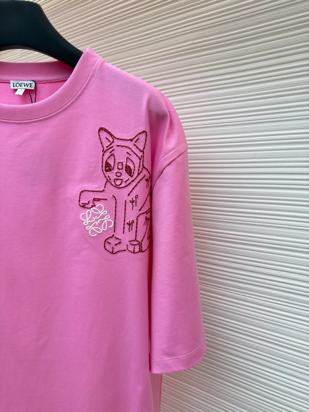 Loewe Cat Line Pattern Round Neck Short Sleeve ●Original version: Purchased and developed at 4330 ●Item number: 1681866-A00 ●Material: combed cotton fabric ●Technology: embroidery production ●Color: pink ●Version: fitted version ●Weight: about 285 grams ●Size: XS-S-M-L ●Description: Made of 15S fine cotton plain fabric, 230g; with 32S double yarn thread, 300g. Plain weave fabric made from combed cotton fibers has a more orderly arrangement and higher density than ordinary cotton, so it has better texture and luster. 15S fine cotton plain fabric is a high-quality cotton fabric with the characteristics of softness, comfort, good breathability, and good durability. Anagram Embroidery Lucky Cat: The rice grain line embroidery process uses special ultra-fine embroidery thread and high-density stitching to create a pattern outline as delicate and continuous as grains. Its core feature lies in the precise arrangement of ultra-fine stitches, which require 12-15 stitches per centimeter to form full lines, and the edges present a handmade micro-waving effect. The fabric achieves a stroke-like gradient of thickness and flow. The overall pattern is light, breathable and smooth to the touch. It looks like a line outline from a distance, but the texture of interwoven fibers can be seen up close. It is especially suitable for expressing delicate details such as logo outlines and geometric borders. Anagram embroidery: Using three-dimensional embroidery technology, the logo clearly restores the spacing curve. The mercerized embroidery thread with luster is selected, combined with complex embroidery needlework and fine detail processing to create a three-dimensional relief embroidery effect. Classic trademark letter design, fine embroidery and dense stitching, clear font and strong sense of lines and three-dimensionality. The overall wiring is straight and delicate, the fabric is comfortable and soft, and the color is consistent without color difference. It can be matched with the same style to create a fashionable look and control various occasions. Customized accessories, complete with three standards, same style for men and women!