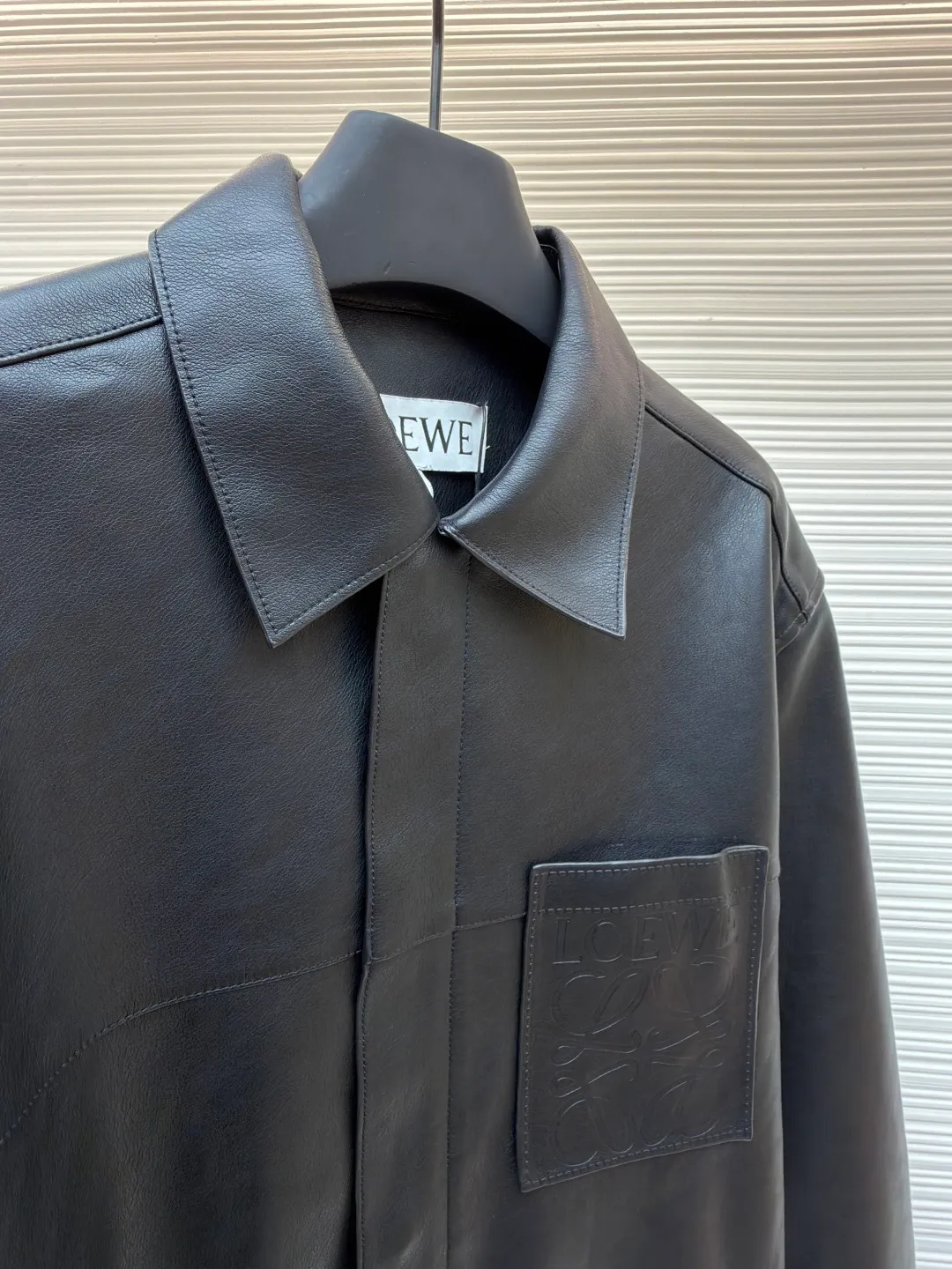 Loewe Anagram pocket zipper leather jacket ●Original version: 38900 purchase and development ●Item number: 1682094-C75 ●Fabric: sheepskin fabric ●Technology: air pump machine embossed production ●Color: black ●Version: fitted version ●Weight: about 1010 grams ●Size: 46-48-50-52 ●Description: Customized ebony pebbled vegetable tanned sheepskin, soft and tough texture, natural texture Presented in matte matte black, the grainy texture reflects subtle light and dark layers under light and shadow, giving static black a dynamic vitality. The iconic Loewe Anagram logo is embellished on the chest patch pocket. It is low-key and powerful. Every inch exudes a low-key and charming luxury luster. Hidden in the public, visible in the wise, it interprets the true connotation of high-end fashion with its versatile appearance. Air pump machine embossed embossing. Through the synergy between precise air pressure control and temperature, the logo pattern is imprinted on the leather surface in a three-dimensional embossed form without damage. Finally, the leather fibers are quickly solidified through a sudden drop in temperature, and the strands are fixed by manual glue. Physical reinforcement technology to fix the seams of the cut pieces through precise point gluing. Manual gluing operation. A wavy glue line is formed along the warp and weft of the cut piece, and the artificial oil edge requires the application of four layers of oil edge agent. Each layer is cooled to a specific temperature and then polished to ensure that the edge is as hard as ceramics and has a uniform gloss. The workmanship is cumbersome and the timeliness is slow. The overall wiring is straight and delicate, the fabric is comfortable and soft, and the color is consistent without color difference. It can be matched with the same style to create a fashionable look and control various occasions. Customized accessories, complete with three standards, same style for men and women!