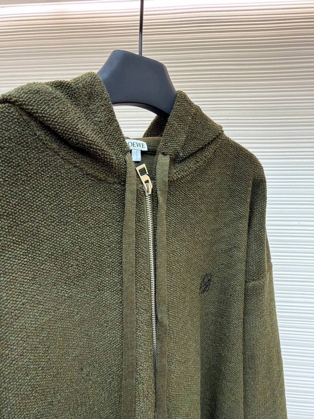 Loewe embroidered hooded zipper cardigan ●Original version: Purchased and developed by 9856 ●Item number: 1682194-B70 ●Material: wool blended fabric ●Technology: embroidery production ●Color: khaki green ●Version: Loose fit ●Weight: about 935 grams ●Size: S-M-L-XL ●Description: Selected high-quality wool as the main body, with unique terry cloth stitching technology, is a highlight of this sweatshirt. This stitching method not only gives the sweatshirt a unique texture and texture, but also demonstrates our stringent quality requirements in every detail. Every seam is tight and even, like a carefully carved work of art, which not only enhances the durability of the clothing, but also adds a unique fashion charm. Ribbed cuffs and hem are the perfect combination of classic and practical. They fit the body well, prevent cold wind from getting in, and provide excellent warmth. At the same time, the elastic properties of the ribs also ensure the comfort of wearing it and will not cause any restrictions on body movements. On the chest, the high-precision calculation system of the computer embroidery machine controls the coordinated operation of the machine head, needle bar, and thread spool. The fabric frame moves accurately in the horizontal and vertical directions to form a stitch track. The upper and lower thread tensions are adjusted to ensure that the stitches are smooth and free of floating threads, forming anagram embroidery with an error of ±0.1mm. The overall wiring is straight and delicate, the fabric is comfortable and soft, and the color is consistent without color difference. It can be matched with the same style to create a fashionable look and control various occasions. Customized accessories, complete with three standards, same style for men and women!