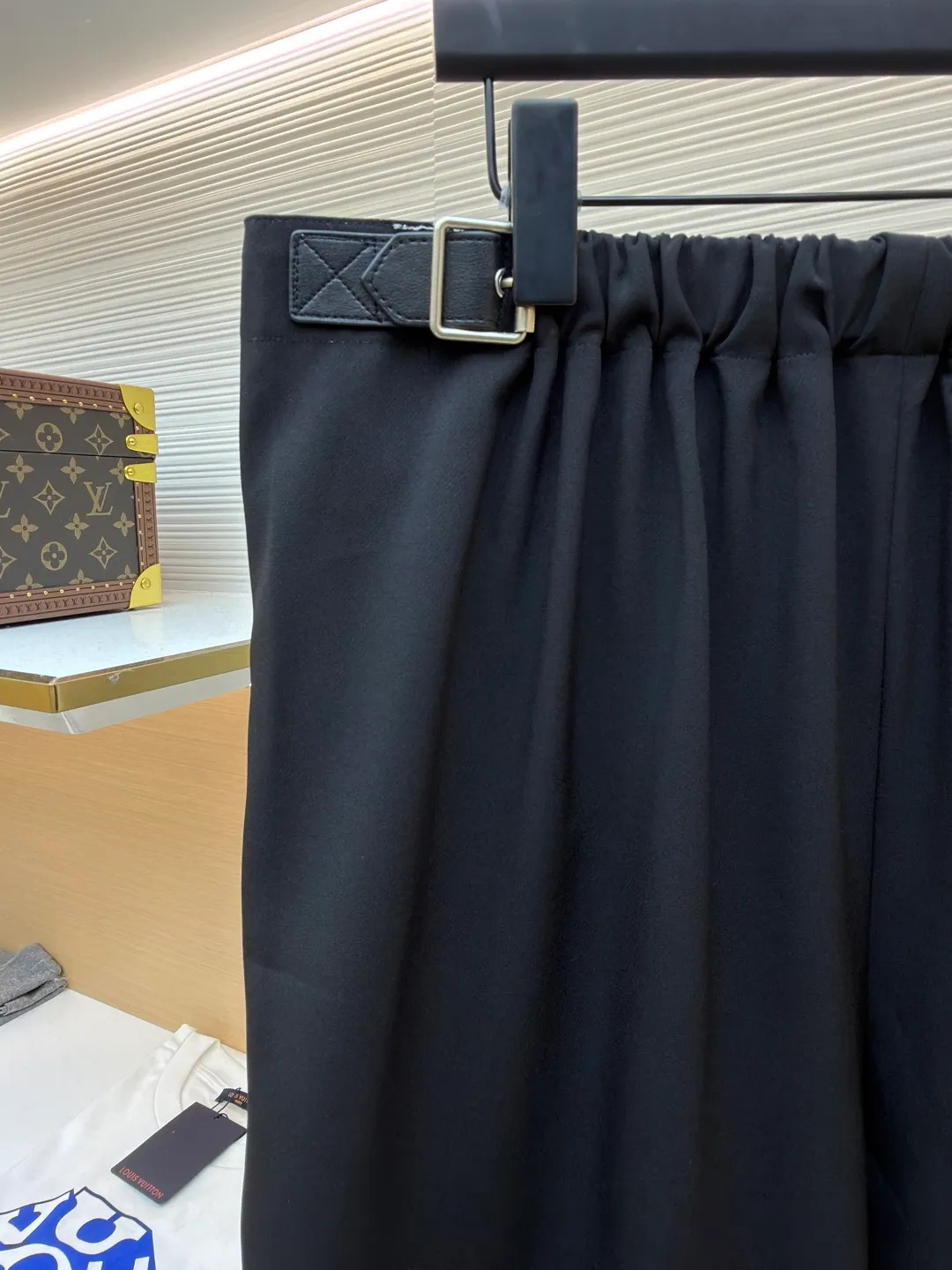 Loewe black belt trousers ●Original version: purchased and developed for 12900 ●Item number: 1682112-B15 ●Fabric: high weight dyed cotton satin fabric ●Technology: leather patch production ●Color: black ●Version: loose fit ●Weight: about 580 grams ●Size: 46-48-50-52 ●Description: Made of high-weight cotton satin fabric, high-weight high-temperature dyed cotton satin fabric is a high-end material with excellent texture and functionality. The core of its technology lies in the selection of high-count, long-staple cotton, and the satin weave method to minimize the interweaving points of warp and weft yarns, thereby forming a unique surface that is smooth, supple and with a faint luster. The high weight ensures that the fabric has a tight structure, is crisp and stylish, and has excellent drape and wear resistance. , "Using high-temperature and high-pressure dyeing technology in the dyeing process, the dye molecules can deeply penetrate into the core of the fiber, thereby achieving high color saturation, strong color fastness and not easy to fade. This process not only gives the fabric a rich and lasting color, but also makes it plump and soft to the touch. It also retains the natural breathability of cotton fiber, achieving a both luxurious and practical wearing experience. The contrasting color decorative belt echoes the theme of military uniforms and allows for flexible waist adjustment; the back is embossed with bronzing leather patches, which use high temperature and high pressure. The brand logo is permanently embossed on the leather and sewn onto the back of the jacket. This process makes the pattern clear and durable, becoming a low-key and powerful symbol of the brand's identity. The style adopts a regular fit and a mid-rise straight design to ensure clean lines and comfortable wearing. The front gathers are an important decorative element and provide room for movement in the functional legs. The pocket design is both practical and simple, while the rear button-stuck welt pocket enhances the sophistication of workwear style.