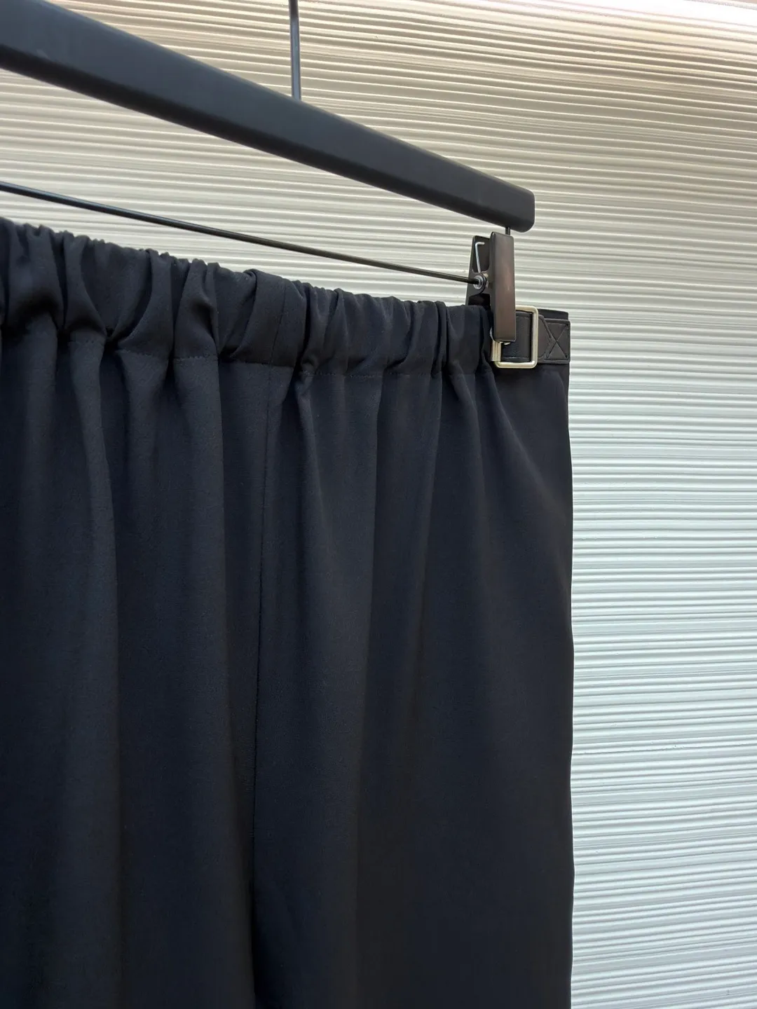Loewe black belt trousers ●Original version: purchased and developed for 12900 ●Item number: 1682112-B15 ●Fabric: high weight dyed cotton satin fabric ●Technology: leather patch production ●Color: black ●Version: loose fit ●Weight: about 580 grams ●Size: 46-48-50-52 ●Description: Made of high-weight cotton satin fabric, high-weight high-temperature dyed cotton satin fabric is a high-end material with excellent texture and functionality. The core of its technology lies in the selection of high-count, long-staple cotton, and the satin weave method to minimize the interweaving points of warp and weft yarns, thereby forming a unique surface that is smooth, supple and with a faint luster. The high weight ensures that the fabric has a tight structure, is crisp and stylish, and has excellent drape and wear resistance. , "Using high-temperature and high-pressure dyeing technology in the dyeing process, the dye molecules can deeply penetrate into the core of the fiber, thereby achieving high color saturation, strong color fastness and not easy to fade. This process not only gives the fabric a rich and lasting color, but also makes it plump and soft to the touch. It also retains the natural breathability of cotton fiber, achieving a both luxurious and practical wearing experience. The contrasting color decorative belt echoes the theme of military uniforms and allows for flexible waist adjustment; the back is embossed with bronzing leather patches, which use high temperature and high pressure. The brand logo is permanently embossed on the leather and sewn onto the back of the jacket. This process makes the pattern clear and durable, becoming a low-key and powerful symbol of the brand's identity. The style adopts a regular fit and a mid-rise straight design to ensure clean lines and comfortable wearing. The front gathers are an important decorative element and provide room for movement in the functional legs. The pocket design is both practical and simple, while the rear button-stuck welt pocket enhances the sophistication of workwear style.