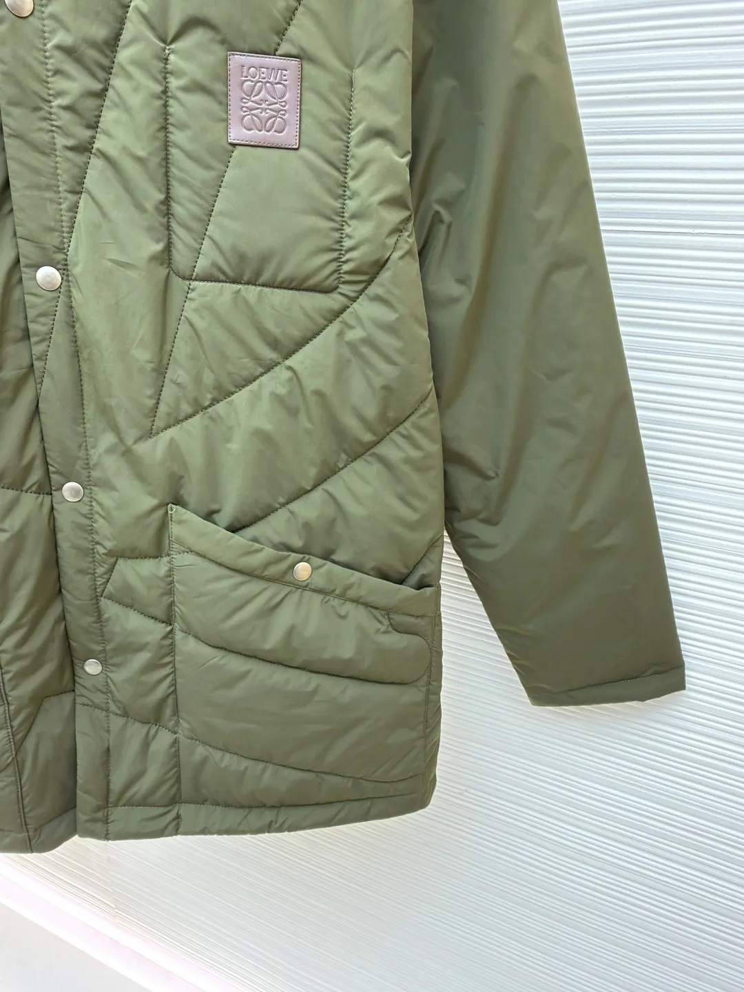 Loewe brown velvet collar quilted cotton jacket ●Original version: purchased and developed by 21571 ●Item number: 1681751-D00 ●Fabric: polyester fiber fabric ●Technology: embossed patch production ●Color: military green ●Version: fitted version ●Weight: about 515 grams ●Size: 44-46-48-50 ●Description: Quilted with technical fabric and thin padding. The main body is made of 100% polyester fiber technical fabric. The fiber has been specially treated to have practical properties such as lightweight, anti-wrinkle, waterproof or high tear strength. The fabric, filling and lining are held together by precise quilting stitches, and the quilted pattern forms the brand's signature. First, it locks the filling to prevent it from shifting or accumulating after use and washing; second, it creates a unique decorative texture that transforms the brand symbol into a three-dimensional texture; and finally, it forms an air insulation layer to provide just the right amount of warmth under the premise of being light, achieving the unity of function and aesthetics. The suede texture of the collar contrasts sharply with the smooth technical fabric of the body, while the embossing adds a new dimension to the suede itself. Corduroy-effect embossed suede collar, using suede as the base material, giving it a soft, luxurious feel and a unique matte look. Through high-temperature embossing technology, a parallel convex texture similar to corduroy is pressed on the suede surface, creating extremely rich visual and tactile levels. The overall wiring is straight and delicate, the fabric is comfortable and soft, and the color is consistent without color difference. It can be matched with the same style to create a fashionable look and control various occasions. Customized accessories, complete with three standards, same style for men and women!