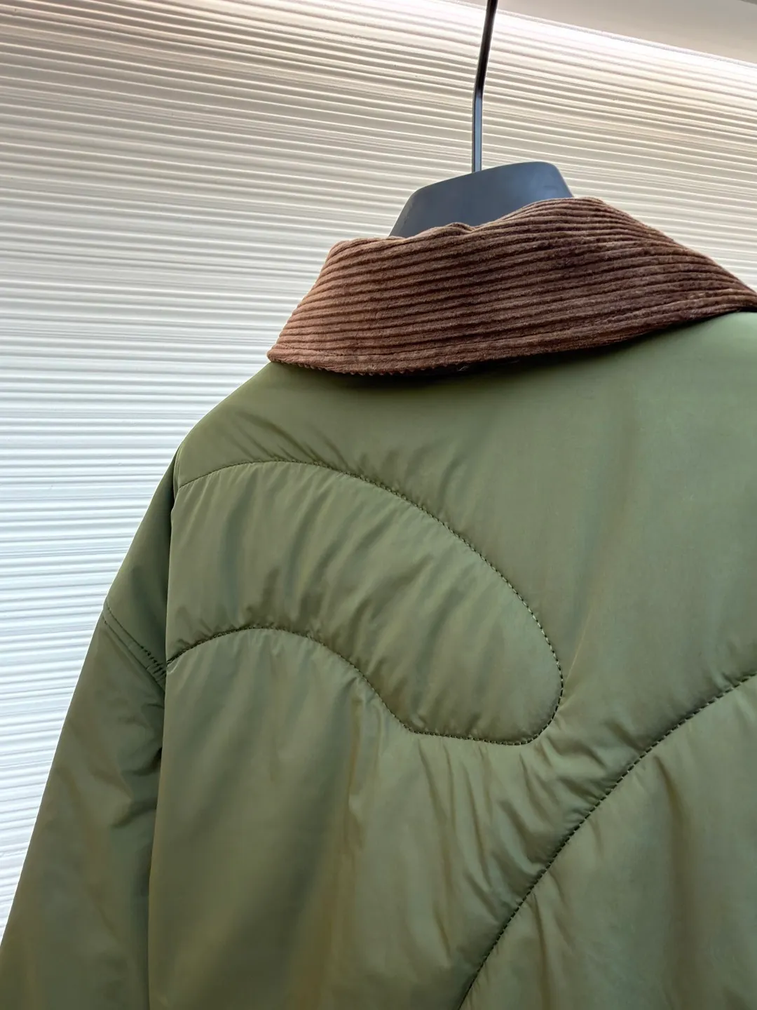 Loewe brown velvet collar quilted cotton jacket ●Original version: purchased and developed by 21571 ●Item number: 1681751-D00 ●Fabric: polyester fiber fabric ●Technology: embossed patch production ●Color: military green ●Version: fitted version ●Weight: about 515 grams ●Size: 44-46-48-50 ●Description: Quilted with technical fabric and thin padding. The main body is made of 100% polyester fiber technical fabric. The fiber has been specially treated to have practical properties such as lightweight, anti-wrinkle, waterproof or high tear strength. The fabric, filling and lining are held together by precise quilting stitches, and the quilted pattern forms the brand's signature. First, it locks the filling to prevent it from shifting or accumulating after use and washing; second, it creates a unique decorative texture that transforms the brand symbol into a three-dimensional texture; and finally, it forms an air insulation layer to provide just the right amount of warmth under the premise of being light, achieving the unity of function and aesthetics. The suede texture of the collar contrasts sharply with the smooth technical fabric of the body, while the embossing adds a new dimension to the suede itself. Corduroy-effect embossed suede collar, using suede as the base material, giving it a soft, luxurious feel and a unique matte look. Through high-temperature embossing technology, a parallel convex texture similar to corduroy is pressed on the suede surface, creating extremely rich visual and tactile levels. The overall wiring is straight and delicate, the fabric is comfortable and soft, and the color is consistent without color difference. It can be matched with the same style to create a fashionable look and control various occasions. Customized accessories, complete with three standards, same style for men and women!
