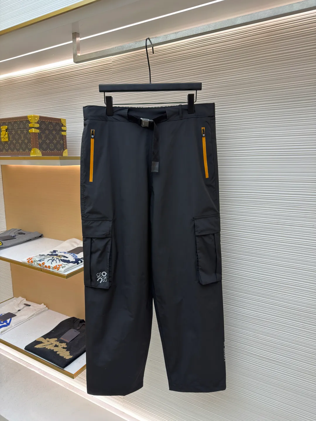 Loewe On co-branded functional sports trousers ●Original version: purchased and developed by 3784 ●Item number: 1681974-B50 ●Fabric: lightweight technical fabric ●Technology: glue printing ●Color: black ●Version: fitted version ●Weight: about 470 grams ●Size: XS-S-M-L ●Description: The main body and lining are made of 100% polyester fiber technical fabric. This synthetic fiber has been specially treated to have core functional properties such as lightweight, high strength, quick-drying and water-repellent, making it ideal for making functional clothing. Mesh lining is used in key areas to significantly improve breathability, accelerate air circulation and avoid stuffiness, thereby providing protection while ensuring comfort. The Anagram On embossed rubber tag on the belt is heat-formed through a mold and is durable, three-dimensional and has a unique tactile feel. The reflective LOEWE On printing on workwear pockets and legs is achieved through a reflective paste printing process. It appears low-key gray under daily light, but when exposed to direct light at night, it will reflect strongly, greatly improving the wearer's visibility and safety in dim environments. The pocket system is the functional core of overalls. The utility flap pockets provide safe storage space and enhance the overall style through a three-dimensional structural design. The multiple side and back waterproof zipper pockets go a step further. By using waterproof taped zippers or laminated waterproof fabrics, important items are absolutely protected from rainwater. The overall wiring is straight and delicate, the fabric is comfortable and soft, and the color is consistent without color difference. It can be matched with the same style to create a fashionable look and control various occasions. Customized accessories, complete with three standards, same style for men and women!