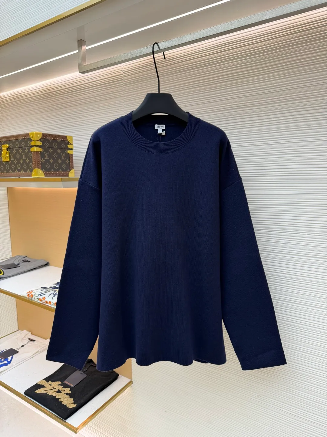 Loewe padded 3D embroidered crew neck sweater ●Original version: purchased and developed by 15168 ●Item number: 1681872-A85 ●Fabric: wool blended fabric ●Technology: 3D embroidery production ●Color: navy blue ●Version: fitted version ●Weight: about 565 grams ●Size: S-M-L-XL ●Description: Made of wool blended fabric, mainly 96% wool, combined with 3% nylon and 1% spandex. The main body of wool ensures the warmth and comfort of the clothing. The addition of a small amount of nylon and spandex significantly improves the elasticity and wear resistance. The ribbed decorative parts are made of 100% wool, which further enhances the texture and wearing experience. Tightly fasten the fabric and cushioning material to the frame of the embroidery machine. The embroidery machine uses sparse stitches along the pattern of the cushion layer to outline the filling area of the pattern. Then it runs the pattern of the overlay layer, using dense stitches to perfectly cover the foam cushion layer, thus forming a slightly raised Anagram embroidery, which is soft and soft to the touch. The full and thick thread layer plays a protective role and greatly improves its wear resistance. Add detergent and preliminarily rinse the bulk goods at a water temperature of about 35 degrees to remove impurities during the production process. The protease is then used to gently digest the hairiness on the surface, thereby reducing the tendency to pilling from the source, improving the feel, retaining softness, and eliminating irritation. Finally, after dehydration and drying, the dimensional and shape stability is improved. The overall wiring is straight and delicate, the fabric is comfortable and soft, and the color is consistent without color difference. It can be matched with the same style to create a fashionable look and control various occasions. Customized accessories, complete with three standards, same style for men and women!