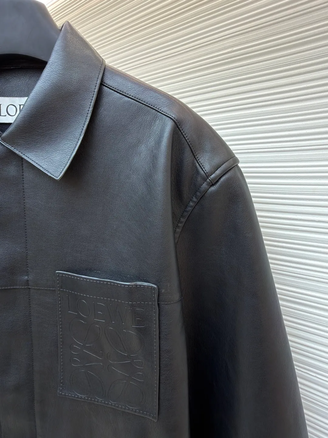 Loewe Anagram pocket zipper leather jacket ●Original version: 38900 purchase and development ●Item number: 1682094-C75 ●Fabric: sheepskin fabric ●Technology: air pump machine embossed production ●Color: black ●Version: fitted version ●Weight: about 1010 grams ●Size: 46-48-50-52 ●Description: Customized ebony pebbled vegetable tanned sheepskin, soft and tough texture, natural texture Presented in matte matte black, the grainy texture reflects subtle light and dark layers under light and shadow, giving static black a dynamic vitality. The iconic Loewe Anagram logo is embellished on the chest patch pocket. It is low-key and powerful. Every inch exudes a low-key and charming luxury luster. Hidden in the public, visible in the wise, it interprets the true connotation of high-end fashion with its versatile appearance. Air pump machine embossed embossing. Through the synergy between precise air pressure control and temperature, the logo pattern is imprinted on the leather surface in a three-dimensional embossed form without damage. Finally, the leather fibers are quickly solidified through a sudden drop in temperature, and the strands are fixed by manual glue. Physical reinforcement technology to fix the seams of the cut pieces through precise point gluing. Manual gluing operation. A wavy glue line is formed along the warp and weft of the cut piece, and the artificial oil edge requires the application of four layers of oil edge agent. Each layer is cooled to a specific temperature and then polished to ensure that the edge is as hard as ceramics and has a uniform gloss. The workmanship is cumbersome and the timeliness is slow. The overall wiring is straight and delicate, the fabric is comfortable and soft, and the color is consistent without color difference. It can be matched with the same style to create a fashionable look and control various occasions. Customized accessories, complete with three standards, same style for men and women!