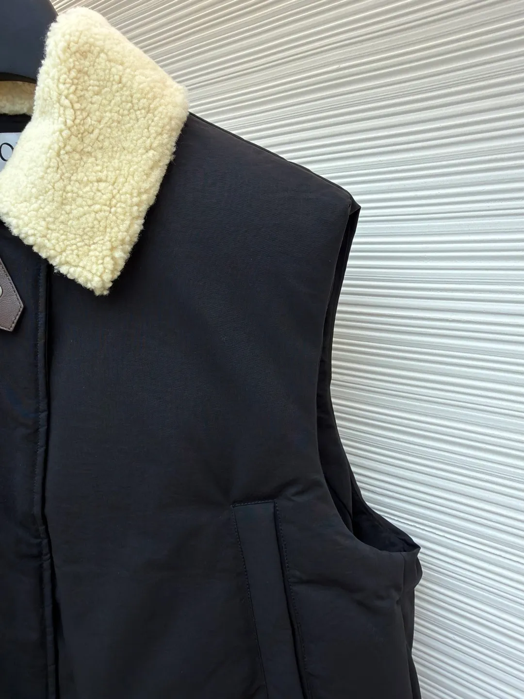 LOEWE lamb collar stitching tie decorative vest ●Original version: Purchased and developed in 19822 ●Item number: 1680962-E65 ●Fabric: sheepskin lamb fabric ●Technology: embroidery production ●Version: Fitted version ●Weight: about 1030 grams ●Size: S-M-L ●Description: Made of Oxford fabric blended with 60% cotton and 40% nylon. Cotton fiber has a natural skin-friendly feel and good moisture absorption and breathability. The addition of nylon improves wear resistance and skeleton strength, while the high-density braid layer enhances the velvet locking effect. The lambswool lapel design effectively wraps the neck and reduces heat loss. Its texture is soft, delicate to the touch, close to the skin and non-irritating, providing a comfortable experience. The furry texture can modify facial lines, making the face look smaller and more refined. It uses 90 white duck down with a weight of 220g to ensure excellent thermal insulation performance. After strict screening and processing, the velvet is not easy to get drilled, ensuring durability. The inner and outer denim fabrics are misaligned by 1.5 cm, blocking the migration path of velvet. The anti-velvet silk thread is used through the imported No. 7 needle to achieve a chain stitch of 14 stitches/inch, resulting in tight and straight stitch spacing and a sewing effect without skipping stitches. The inner bag surface is formed into high-precision Anagram embroidery with about 6,000 stitches through the advanced computer control system and precision mechanical components of the imported embroidery machine. The overall wiring is straight and delicate, the fabric is comfortable and soft, and the color is consistent without color difference. It can be matched with the same style to create a fashionable look and control various occasions. Customized accessories, complete with three standards, same style for men and women!