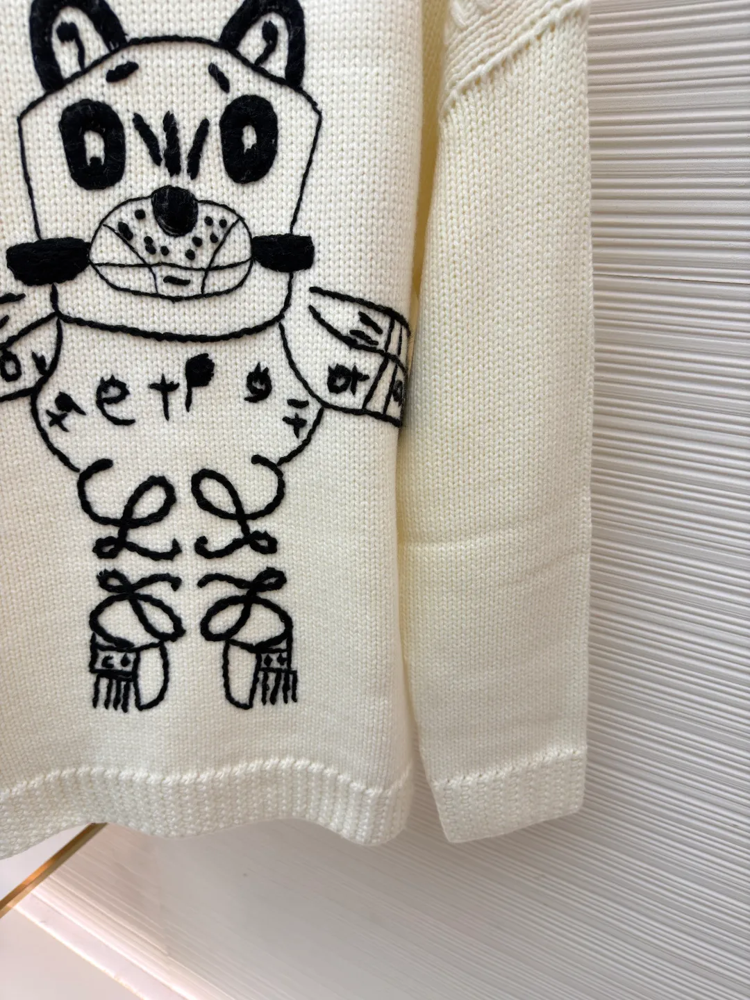 Loewe cat star round neck embroidered long-sleeved sweater ●Original version: purchased and developed by 19451 ●Item number: 1682139-C05 ●Fabric: wool blended fabric ●Technology: knitted embroidery production ●Color: white ●Version: fitted version ●Weight: about 740 grams ●Size: S-M-L-XL ●Description: This Loewe cat embroidered totem thick needle knitted sweater is made of imported merino wool woolen yarn and woven with an 8-needle thick needle plain knitting process. The yarn has been pre-washed and milled and anti-pilling, giving the garment a soft and waxy feel and a crisp texture. The loose shoulder style is formed in one go by an Italian computerized flat machine, which reduces stitching and makes it more neat. The cat totem on the front uses a combination of three-dimensional chain embroidery + satin embroidery, using high-tenacity black cotton blended embroidery thread. It is completed by hand stitch by stitch by senior embroidery workers. The outline of the pattern is smooth and full of three-dimensionality. The bottom layer of embroidery is paved with non-woven interlining to prevent the embroidery thread from pulling and causing the body to deform. The neckline, cuffs and hem are all designed with double-ply ribbing and built-in elastic spandex yarn. It has excellent resilience after high-temperature setting treatment. The low-temperature steam process is used during manual ironing to retain the natural texture and silhouette of the wool yarn to the greatest extent. The overall wiring is straight and delicate, the fabric is comfortable and soft, and the color is consistent without color difference. It can be matched with the same style to create a fashionable look and control various occasions. Customized accessories, complete with three standards, same style for men and women!