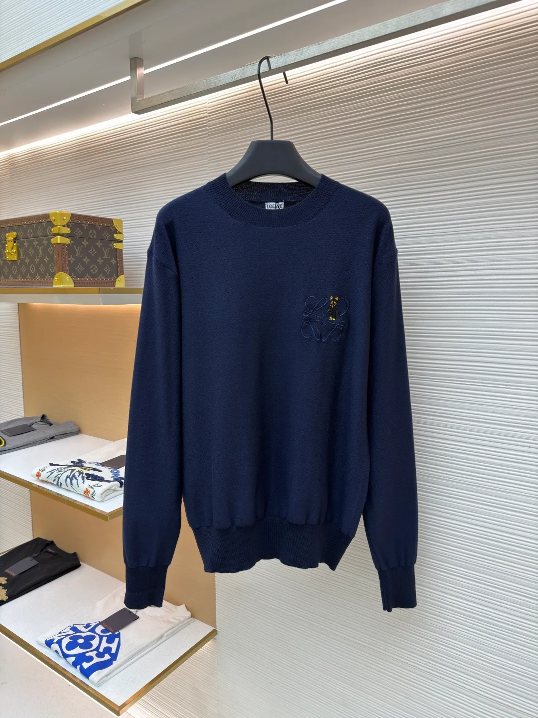Loewe jersey stitched crew neck embroidered sweater ●Original version: purchased and developed by 8395 ●Item number: 1682517-A45 ●Fabric: wool fabric ●Technology: knitted embroidery production ●Color: navy blue ●Version: fitted version ●Weight: about 305 grams ●Size: S-M-L-XL ●Description: This LOEWE navy blue knitted sweater is knitted with high-quality merino wool blended yarn and uses plain knitting technology to create the body. The fabric is fine, soft, waxy and elastic, with both warmth retention and breathability, and is not prone to pilling or snagging. The brand's classic embroidery pattern on the left chest is made of the same color and gold embroidery thread, and is made with fine appliqué technology. The pattern is three-dimensional and vivid, with dense stitching, forming a low-key texture contrast with the knitted base, highlighting the brand's recognition. The neckline is a classic round neck design, with double-needle reinforced hemming technology and a custom-made threaded collar, making it durable and not prone to loosening. The cuffs and hem are designed with ribbed edges, with moderate elasticity to fit the body shape. The overall cut is a loose silhouette, with straight and fine stitching lines. Customized accessories and three labels are complete. The details and craftsmanship show the level of luxury. It is suitable for casual daily and light business wear scenarios. The overall wiring is straight and delicate, the fabric is comfortable and soft, and the color is consistent without color difference. It can be matched with the same style to create a fashionable look and control various occasions. Customized accessories, complete with three standards, same style for men and women!