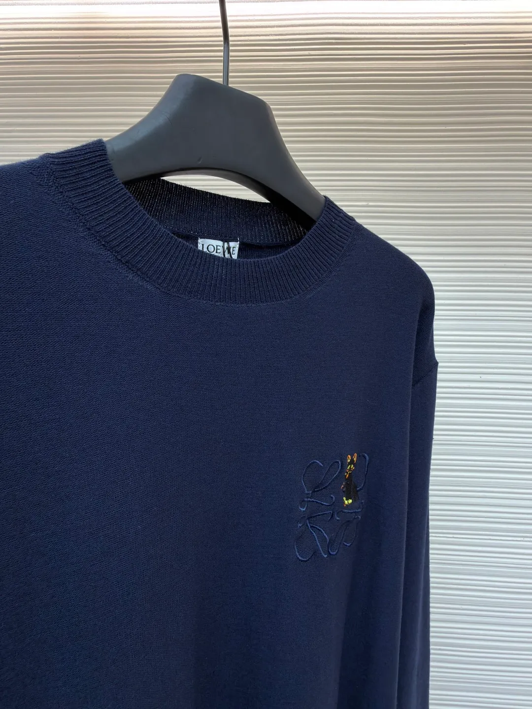 Loewe jersey stitched crew neck embroidered sweater ●Original version: purchased and developed by 8395 ●Item number: 1682517-A45 ●Fabric: wool fabric ●Technology: knitted embroidery production ●Color: navy blue ●Version: fitted version ●Weight: about 305 grams ●Size: S-M-L-XL ●Description: This LOEWE navy blue knitted sweater is knitted with high-quality merino wool blended yarn and uses plain knitting technology to create the body. The fabric is fine, soft, waxy and elastic, with both warmth retention and breathability, and is not prone to pilling or snagging. The brand's classic embroidery pattern on the left chest is made of the same color and gold embroidery thread, and is made with fine appliqué technology. The pattern is three-dimensional and vivid, with dense stitching, forming a low-key texture contrast with the knitted base, highlighting the brand's recognition. The neckline is a classic round neck design, with double-needle reinforced hemming technology and a custom-made threaded collar, making it durable and not prone to loosening. The cuffs and hem are designed with ribbed edges, with moderate elasticity to fit the body shape. The overall cut is a loose silhouette, with straight and fine stitching lines. Customized accessories and three labels are complete. The details and craftsmanship show the level of luxury. It is suitable for casual daily and light business wear scenarios. The overall wiring is straight and delicate, the fabric is comfortable and soft, and the color is consistent without color difference. It can be matched with the same style to create a fashionable look and control various occasions. Customized accessories, complete with three standards, same style for men and women!