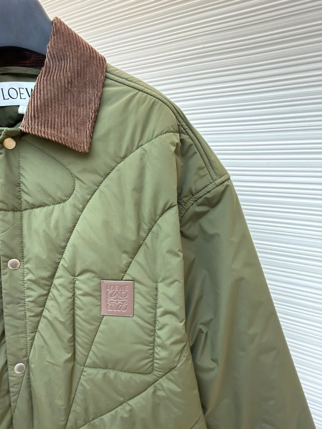 Loewe brown velvet collar quilted cotton jacket ●Original version: purchased and developed by 21571 ●Item number: 1681751-D00 ●Fabric: polyester fiber fabric ●Technology: embossed patch production ●Color: military green ●Version: fitted version ●Weight: about 515 grams ●Size: 44-46-48-50 ●Description: Quilted with technical fabric and thin padding. The main body is made of 100% polyester fiber technical fabric. The fiber has been specially treated to have practical properties such as lightweight, anti-wrinkle, waterproof or high tear strength. The fabric, filling and lining are held together by precise quilting stitches, and the quilted pattern forms the brand's signature. First, it locks the filling to prevent it from shifting or accumulating after use and washing; second, it creates a unique decorative texture that transforms the brand symbol into a three-dimensional texture; and finally, it forms an air insulation layer to provide just the right amount of warmth under the premise of being light, achieving the unity of function and aesthetics. The suede texture of the collar contrasts sharply with the smooth technical fabric of the body, while the embossing adds a new dimension to the suede itself. Corduroy-effect embossed suede collar, using suede as the base material, giving it a soft, luxurious feel and a unique matte look. Through high-temperature embossing technology, a parallel convex texture similar to corduroy is pressed on the suede surface, creating extremely rich visual and tactile levels. The overall wiring is straight and delicate, the fabric is comfortable and soft, and the color is consistent without color difference. It can be matched with the same style to create a fashionable look and control various occasions. Customized accessories, complete with three standards, same style for men and women!