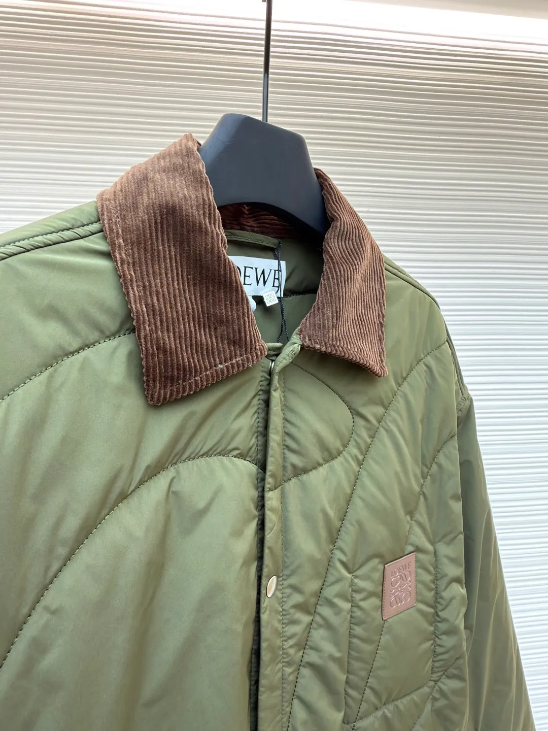 Loewe brown velvet collar quilted cotton jacket ●Original version: purchased and developed by 21571 ●Item number: 1681751-D00 ●Fabric: polyester fiber fabric ●Technology: embossed patch production ●Color: military green ●Version: fitted version ●Weight: about 515 grams ●Size: 44-46-48-50 ●Description: Quilted with technical fabric and thin padding. The main body is made of 100% polyester fiber technical fabric. The fiber has been specially treated to have practical properties such as lightweight, anti-wrinkle, waterproof or high tear strength. The fabric, filling and lining are held together by precise quilting stitches, and the quilted pattern forms the brand's signature. First, it locks the filling to prevent it from shifting or accumulating after use and washing; second, it creates a unique decorative texture that transforms the brand symbol into a three-dimensional texture; and finally, it forms an air insulation layer to provide just the right amount of warmth under the premise of being light, achieving the unity of function and aesthetics. The suede texture of the collar contrasts sharply with the smooth technical fabric of the body, while the embossing adds a new dimension to the suede itself. Corduroy-effect embossed suede collar, using suede as the base material, giving it a soft, luxurious feel and a unique matte look. Through high-temperature embossing technology, a parallel convex texture similar to corduroy is pressed on the suede surface, creating extremely rich visual and tactile levels. The overall wiring is straight and delicate, the fabric is comfortable and soft, and the color is consistent without color difference. It can be matched with the same style to create a fashionable look and control various occasions. Customized accessories, complete with three standards, same style for men and women!