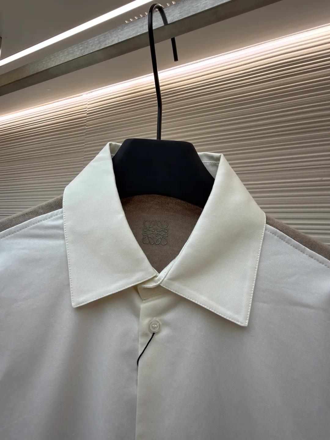 LOEWE cotton and knitted spliced shirt ●Original version: purchased and developed by 12479 ●Item number: 1680887-B50 ●Fabric: high-count cotton yarn fabric ●Technology: mechanical embroidery production ●Version: fitted version ●Weight: about 350 grams ●Size: 36-38-40-42 ●Description: The front panel is made of high-count cotton yarn through a weaving process with high warp density and low weft density to make a light and thin fabric with excellent breathability. The surface is smooth and flat, and feels as smooth as silk. At the same time, it retains the natural skin-friendly properties of cotton, making it snug and comfortable without any strange feeling. Because the warp yarns are closely arranged, the surface of the fabric shows longitudinal texture and soft luster, enhancing the visual sense of luxury. The back panel is woven with extremely fine wool yarn through high-count spinning technology to make a fabric with moderate density. It feels soft and skin-friendly, and has a delicate velvet feel on the surface. Wool fiber has a natural hollow structure, which can lock in still air and form an excellent thermal insulation layer. Even if it is light and thin, it has a good thermal insulation effect. Under the back collar, the high-precision calculation system of the computerized embroidery machine controls the coordinated operation of the machine head, needle bar, and thread spool. The fabric frame moves accurately in the horizontal and vertical directions to form a stitch track. The upper and lower thread tensions are adjusted to ensure that the stitches are smooth and free of floating threads, forming anagram embroidery with an error of ±0.1mm. The overall wiring is straight and delicate, the fabric is comfortable and soft, and the color is consistent without color difference. It can be matched with the same style to create a fashionable look and control various occasions. Customized accessories, complete with three standards, same style for men and women!