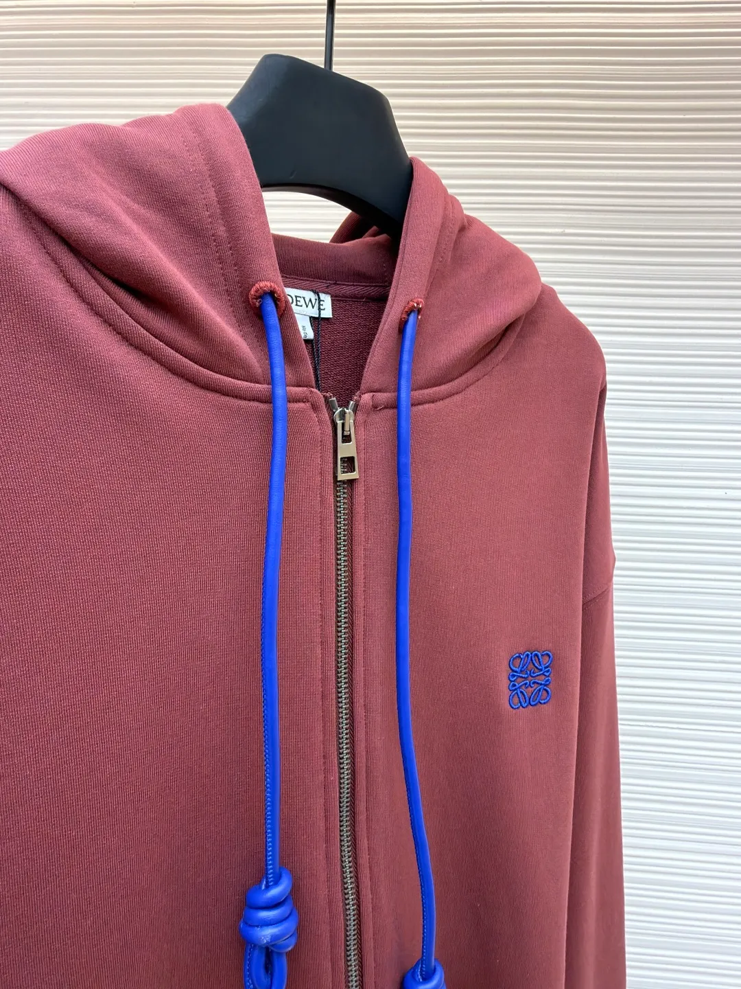 Loewe terry cotton fleece zipper hooded sweatshirt ●Original version: purchased and developed by 9473 ●Item number: 1682251-B05 ●Fabric: terry fabric ●Technology: Fleece production ●Color: burgundy ●Version: fitted version ●Weight: about 915 grams ●Size: S-M-L-XL ●Description: This Loewe hooded zipper sweatshirt is made of 460g heavyweight pure cotton terry cloth. The fabric has been combed to remove short velvet impurities and is soft and not easy to pill. It is also pre-washed and shaped to effectively prevent shrinkage and deformation after wearing. The burgundy color is low-temperature dip-dyed with plant dyes. The color is full, skin-friendly and non-irritating. The brand logo on the left side of the body adopts the same color hidden thread embroidery process. The embroidery stitches follow dense embroidery techniques. The outline of the pattern is clear and three-dimensional, integrating with the body of the garment without being obtrusive. The drawstring is made of high-elastic nylon rope, which is hand-knitted to form a unique knot decoration. The blue and red contrasting design adds visual highlights. The zipper is a custom-made metal two-way zipper with matte electroplated teeth that pull smoothly and are not easily oxidized. The ribs on the cuffs and hem are made of spandex blended material. After shaping process, it has excellent resilience and fits the body shape without being tight. The overall cut is a loose shoulder-drop version, combined with the flat car double-line stitching process, taking into account both comfort and durability, showing the craftsmanship of light luxury clothing. The overall wiring is straight and delicate, the fabric is comfortable and soft, and the color is consistent without color difference. It can be matched with the same style to create a fashionable look and control various occasions. Customized accessories, complete with three standards, same style for men and women!