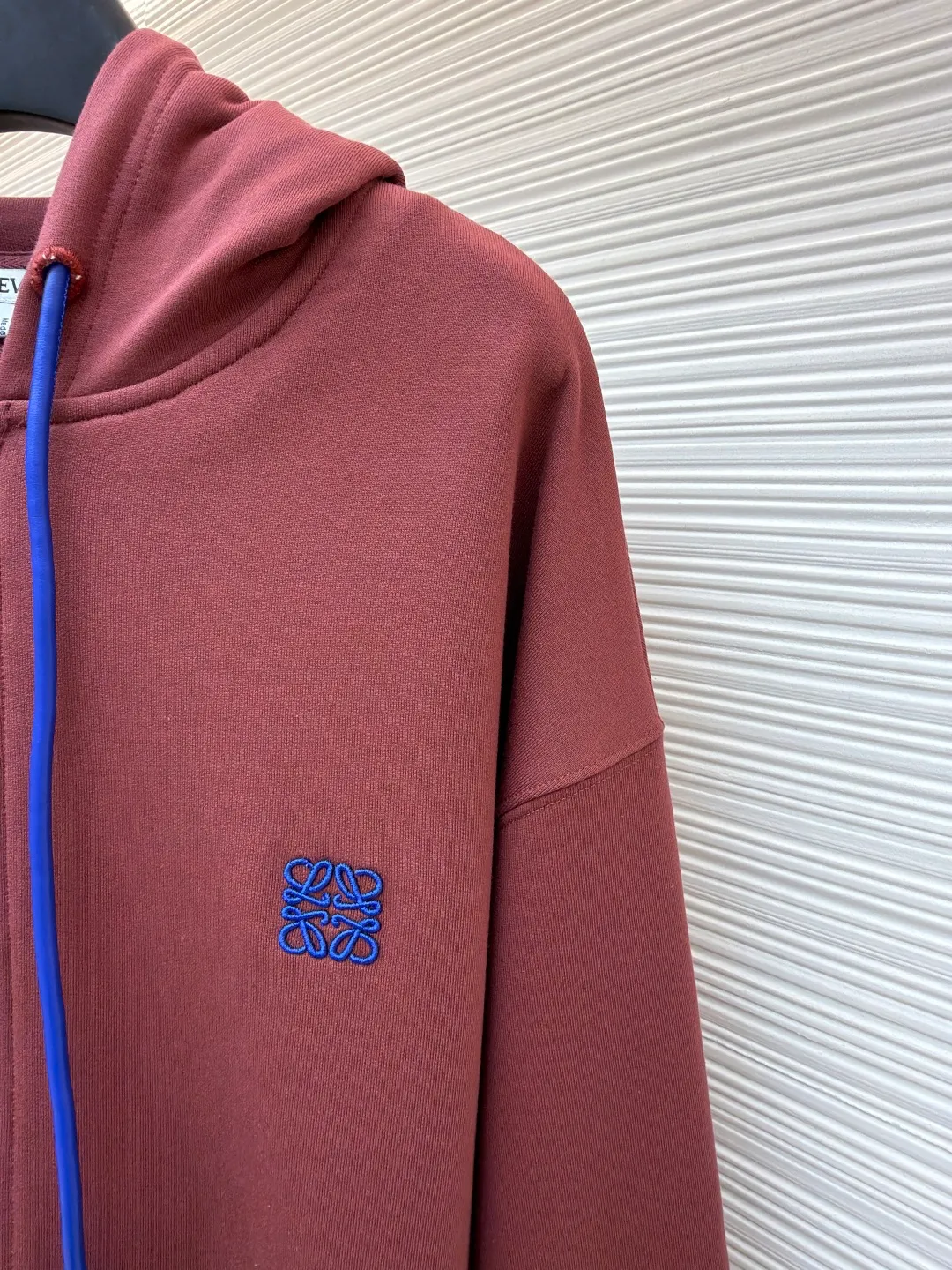 Loewe terry cotton fleece zipper hooded sweatshirt ●Original version: purchased and developed by 9473 ●Item number: 1682251-B05 ●Fabric: terry fabric ●Technology: Fleece production ●Color: burgundy ●Version: fitted version ●Weight: about 915 grams ●Size: S-M-L-XL ●Description: This Loewe hooded zipper sweatshirt is made of 460g heavyweight pure cotton terry cloth. The fabric has been combed to remove short velvet impurities and is soft and not easy to pill. It is also pre-washed and shaped to effectively prevent shrinkage and deformation after wearing. The burgundy color is low-temperature dip-dyed with plant dyes. The color is full, skin-friendly and non-irritating. The brand logo on the left side of the body adopts the same color hidden thread embroidery process. The embroidery stitches follow dense embroidery techniques. The outline of the pattern is clear and three-dimensional, integrating with the body of the garment without being obtrusive. The drawstring is made of high-elastic nylon rope, which is hand-knitted to form a unique knot decoration. The blue and red contrasting design adds visual highlights. The zipper is a custom-made metal two-way zipper with matte electroplated teeth that pull smoothly and are not easily oxidized. The ribs on the cuffs and hem are made of spandex blended material. After shaping process, it has excellent resilience and fits the body shape without being tight. The overall cut is a loose shoulder-drop version, combined with the flat car double-line stitching process, taking into account both comfort and durability, showing the craftsmanship of light luxury clothing. The overall wiring is straight and delicate, the fabric is comfortable and soft, and the color is consistent without color difference. It can be matched with the same style to create a fashionable look and control various occasions. Customized accessories, complete with three standards, same style for men and women!