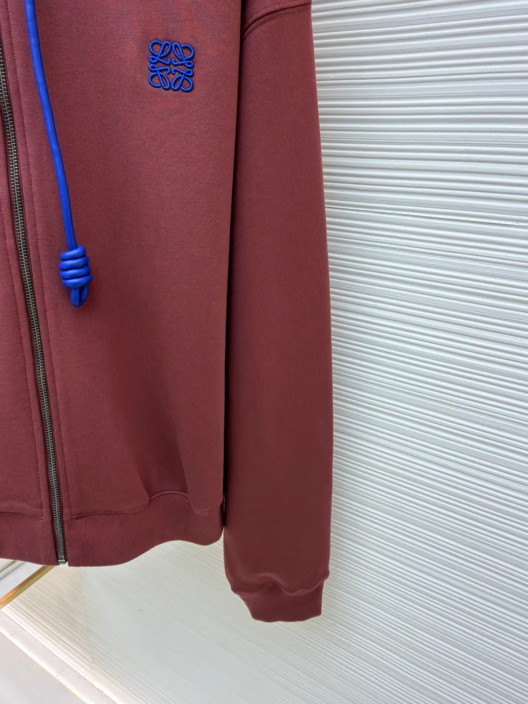 Loewe terry cotton fleece zipper hooded sweatshirt ●Original version: purchased and developed by 9473 ●Item number: 1682251-B05 ●Fabric: terry fabric ●Technology: Fleece production ●Color: burgundy ●Version: fitted version ●Weight: about 915 grams ●Size: S-M-L-XL ●Description: This Loewe hooded zipper sweatshirt is made of 460g heavyweight pure cotton terry cloth. The fabric has been combed to remove short velvet impurities and is soft and not easy to pill. It is also pre-washed and shaped to effectively prevent shrinkage and deformation after wearing. The burgundy color is low-temperature dip-dyed with plant dyes. The color is full, skin-friendly and non-irritating. The brand logo on the left side of the body adopts the same color hidden thread embroidery process. The embroidery stitches follow dense embroidery techniques. The outline of the pattern is clear and three-dimensional, integrating with the body of the garment without being obtrusive. The drawstring is made of high-elastic nylon rope, which is hand-knitted to form a unique knot decoration. The blue and red contrasting design adds visual highlights. The zipper is a custom-made metal two-way zipper with matte electroplated teeth that pull smoothly and are not easily oxidized. The ribs on the cuffs and hem are made of spandex blended material. After shaping process, it has excellent resilience and fits the body shape without being tight. The overall cut is a loose shoulder-drop version, combined with the flat car double-line stitching process, taking into account both comfort and durability, showing the craftsmanship of light luxury clothing. The overall wiring is straight and delicate, the fabric is comfortable and soft, and the color is consistent without color difference. It can be matched with the same style to create a fashionable look and control various occasions. Customized accessories, complete with three standards, same style for men and women!