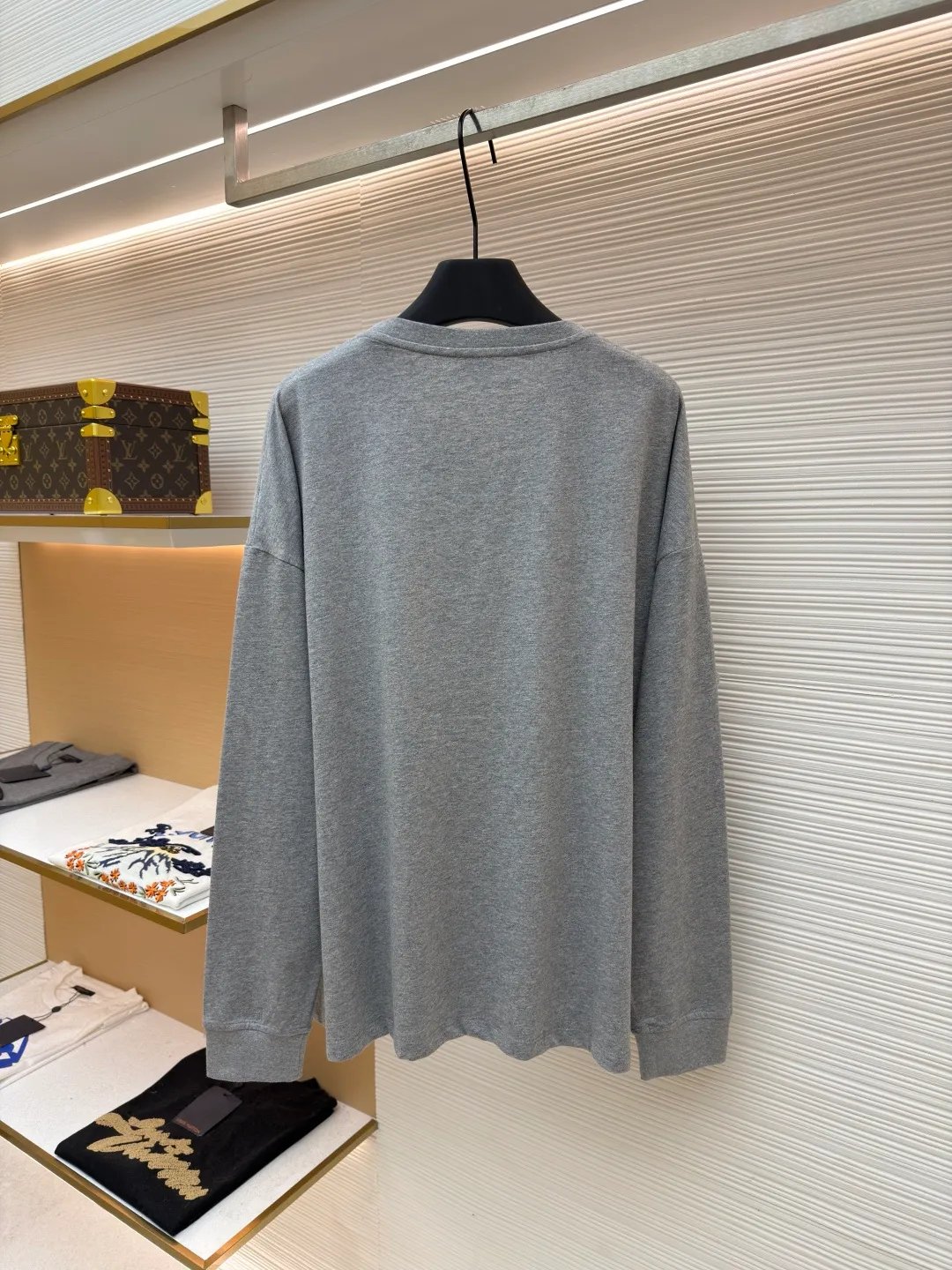 Loewe Stone Cat Round Neck Long Sleeve ●Original version: Purchased and developed by 5148 ●Item number: 1681939-A15 ●Fabric: Cotton jersey fabric ●Technology: Rice grain line embroidery production ●Color: gray ●Version: Fitted version ●Weight: about 250 grams ●Size: High-count combed cotton yarn eliminates most of the short hairiness through compact spinning process, making the yarn smoother and stronger. The woven fabric structure is extremely dense, flat and soft, with excellent anti-pilling ability and durability, while retaining the natural advantages of pure cotton, which is breathable and skin-friendly. The neckline is made of 32S 1x1 rib with a weight of 300g. The finer yarn count creates a more delicate and tight thread, which provides better resilience and anti-deformation than ordinary ribs, ensuring that the neckline can still remain stiff after being put on and taken off many times. The rice grain line embroidery process uses special ultra-fine embroidery thread and high-density stitching to create a pattern outline as delicate and continuous as grains. Its core feature lies in the precise arrangement of ultra-fine stitches, which require 12-15 stitches per centimeter to form full lines, and the edges present a handmade micro-waving effect. The fabric achieves a stroke-like gradient of thickness and flow. The overall pattern is light, breathable and smooth to the touch. It looks like a line outline from a distance, but the texture of interwoven fibers can be seen up close. It is especially suitable for expressing delicate details such as logo outlines and geometric borders. Anagram embroidery: Using three-dimensional embroidery technology, the logo clearly restores the spacing curve. The mercerized embroidery thread with luster is selected, combined with complex embroidery needlework and fine detail processing to create a three-dimensional relief embroidery effect. Classic trademark letter design, fine embroidery and dense stitching, clear font and strong sense of lines and three-dimensionality. The overall wiring is straight and delicate, the fabric is comfortable and soft, and the color is consistent without color difference. It can be matched with the same style to create a fashionable look and control various occasions. Customized accessories, complete with three standards, same style for men and women!