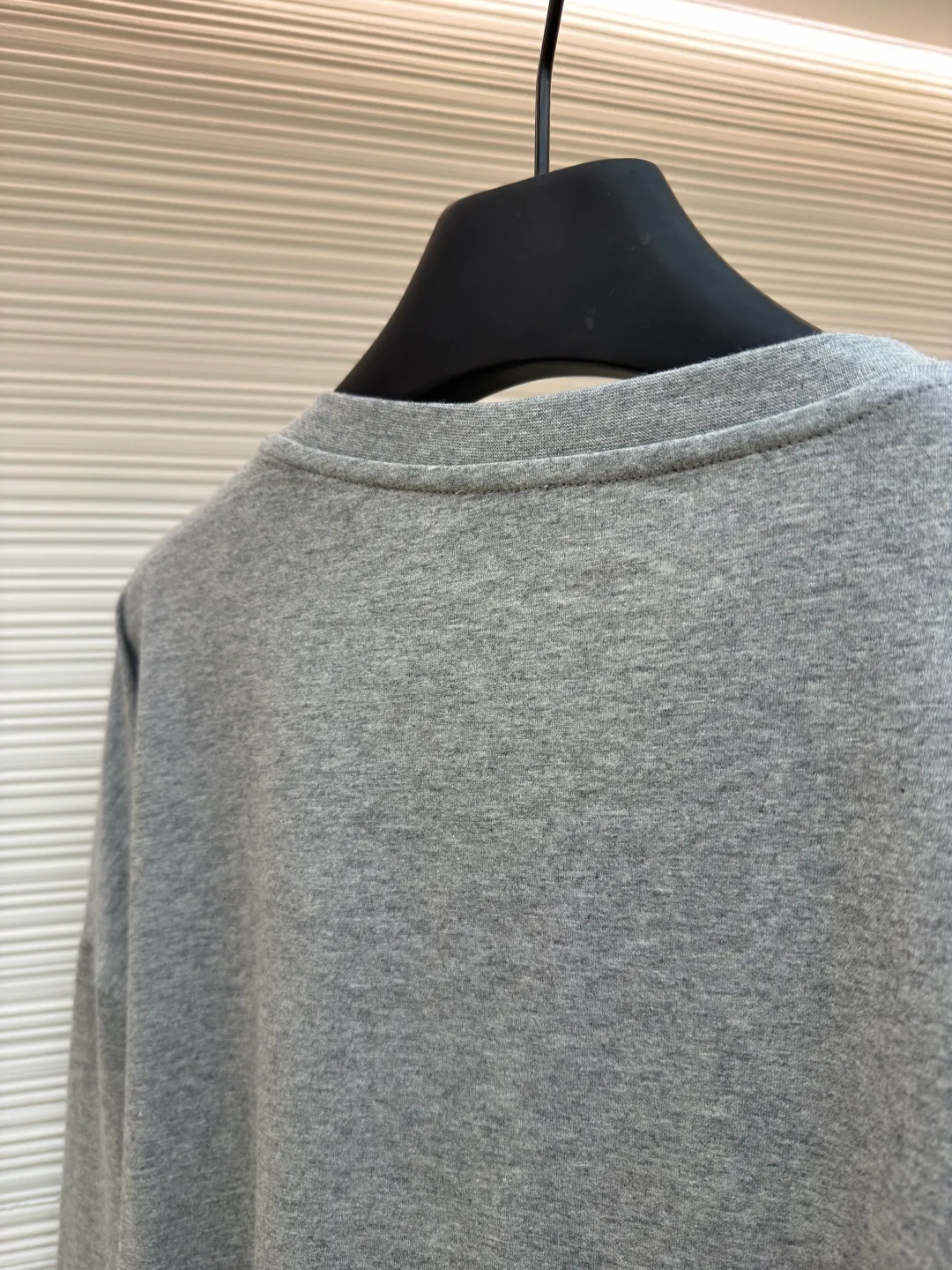 Loewe Stone Cat Round Neck Long Sleeve ●Original version: Purchased and developed by 5148 ●Item number: 1681939-A15 ●Fabric: Cotton jersey fabric ●Technology: Rice grain line embroidery production ●Color: gray ●Version: Fitted version ●Weight: about 250 grams ●Size: High-count combed cotton yarn eliminates most of the short hairiness through compact spinning process, making the yarn smoother and stronger. The woven fabric structure is extremely dense, flat and soft, with excellent anti-pilling ability and durability, while retaining the natural advantages of pure cotton, which is breathable and skin-friendly. The neckline is made of 32S 1x1 rib with a weight of 300g. The finer yarn count creates a more delicate and tight thread, which provides better resilience and anti-deformation than ordinary ribs, ensuring that the neckline can still remain stiff after being put on and taken off many times. The rice grain line embroidery process uses special ultra-fine embroidery thread and high-density stitching to create a pattern outline as delicate and continuous as grains. Its core feature lies in the precise arrangement of ultra-fine stitches, which require 12-15 stitches per centimeter to form full lines, and the edges present a handmade micro-waving effect. The fabric achieves a stroke-like gradient of thickness and flow. The overall pattern is light, breathable and smooth to the touch. It looks like a line outline from a distance, but the texture of interwoven fibers can be seen up close. It is especially suitable for expressing delicate details such as logo outlines and geometric borders. Anagram embroidery: Using three-dimensional embroidery technology, the logo clearly restores the spacing curve. The mercerized embroidery thread with luster is selected, combined with complex embroidery needlework and fine detail processing to create a three-dimensional relief embroidery effect. Classic trademark letter design, fine embroidery and dense stitching, clear font and strong sense of lines and three-dimensionality. The overall wiring is straight and delicate, the fabric is comfortable and soft, and the color is consistent without color difference. It can be matched with the same style to create a fashionable look and control various occasions. Customized accessories, complete with three standards, same style for men and women!