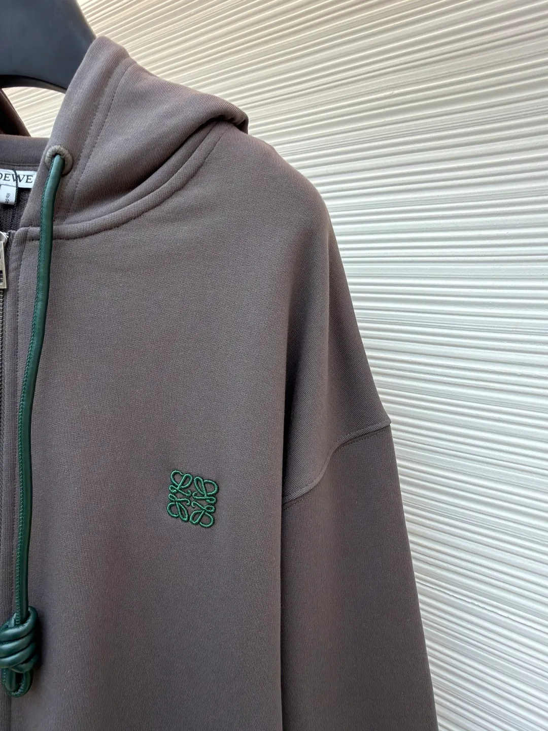 Loewe terry cotton fleece zipper hooded sweatshirt ●Original version: purchased and developed by 9473 ●Item number: 1682252-B05 ●Fabric: terry fabric ●Technology: Fleece production ●Color: gray ●Version: fitted version ●Weight: about 930 grams ●Size: S-M-L-XL ●Description: This Loewe hooded zipper sweatshirt is made of 460g heavyweight pure cotton terry cloth. The fabric has been combed to remove short velvet impurities and is soft and not easy to pill. It is also pre-washed and shaped to effectively prevent shrinkage and deformation after wearing. The burgundy color is low-temperature dip-dyed with plant dyes. The color is full, skin-friendly and non-irritating. The brand logo on the left side of the body adopts the same color hidden thread embroidery process. The embroidery stitches follow dense embroidery techniques. The outline of the pattern is clear and three-dimensional, integrating with the body of the garment without being obtrusive. The drawstring is made of high-elastic nylon rope, which is hand-knitted to form a unique knot decoration. The blue and red contrasting design adds visual highlights. The zipper is a custom-made metal two-way zipper with matte electroplated teeth that pull smoothly and are not easily oxidized. The ribs on the cuffs and hem are made of spandex blended material. After shaping process, it has excellent resilience and fits the body shape without being tight. The overall cut is a loose shoulder-drop version, combined with the flat car double-line stitching process, taking into account both comfort and durability, showing the craftsmanship of light luxury clothing. The overall wiring is straight and delicate, the fabric is comfortable and soft, and the color is consistent without color difference. It can be matched with the same style to create a fashionable look and control various occasions. Customized accessories, complete with three standards, same style for men and women!