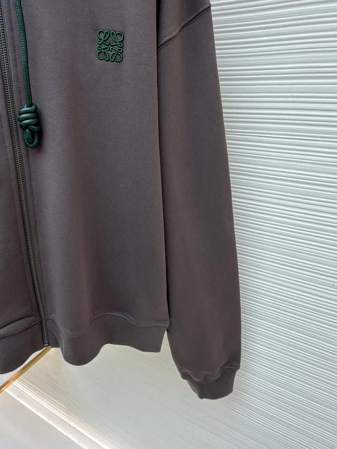 Loewe terry cotton fleece zipper hooded sweatshirt ●Original version: purchased and developed by 9473 ●Item number: 1682252-B05 ●Fabric: terry fabric ●Technology: Fleece production ●Color: gray ●Version: fitted version ●Weight: about 930 grams ●Size: S-M-L-XL ●Description: This Loewe hooded zipper sweatshirt is made of 460g heavyweight pure cotton terry cloth. The fabric has been combed to remove short velvet impurities and is soft and not easy to pill. It is also pre-washed and shaped to effectively prevent shrinkage and deformation after wearing. The burgundy color is low-temperature dip-dyed with plant dyes. The color is full, skin-friendly and non-irritating. The brand logo on the left side of the body adopts the same color hidden thread embroidery process. The embroidery stitches follow dense embroidery techniques. The outline of the pattern is clear and three-dimensional, integrating with the body of the garment without being obtrusive. The drawstring is made of high-elastic nylon rope, which is hand-knitted to form a unique knot decoration. The blue and red contrasting design adds visual highlights. The zipper is a custom-made metal two-way zipper with matte electroplated teeth that pull smoothly and are not easily oxidized. The ribs on the cuffs and hem are made of spandex blended material. After shaping process, it has excellent resilience and fits the body shape without being tight. The overall cut is a loose shoulder-drop version, combined with the flat car double-line stitching process, taking into account both comfort and durability, showing the craftsmanship of light luxury clothing. The overall wiring is straight and delicate, the fabric is comfortable and soft, and the color is consistent without color difference. It can be matched with the same style to create a fashionable look and control various occasions. Customized accessories, complete with three standards, same style for men and women!