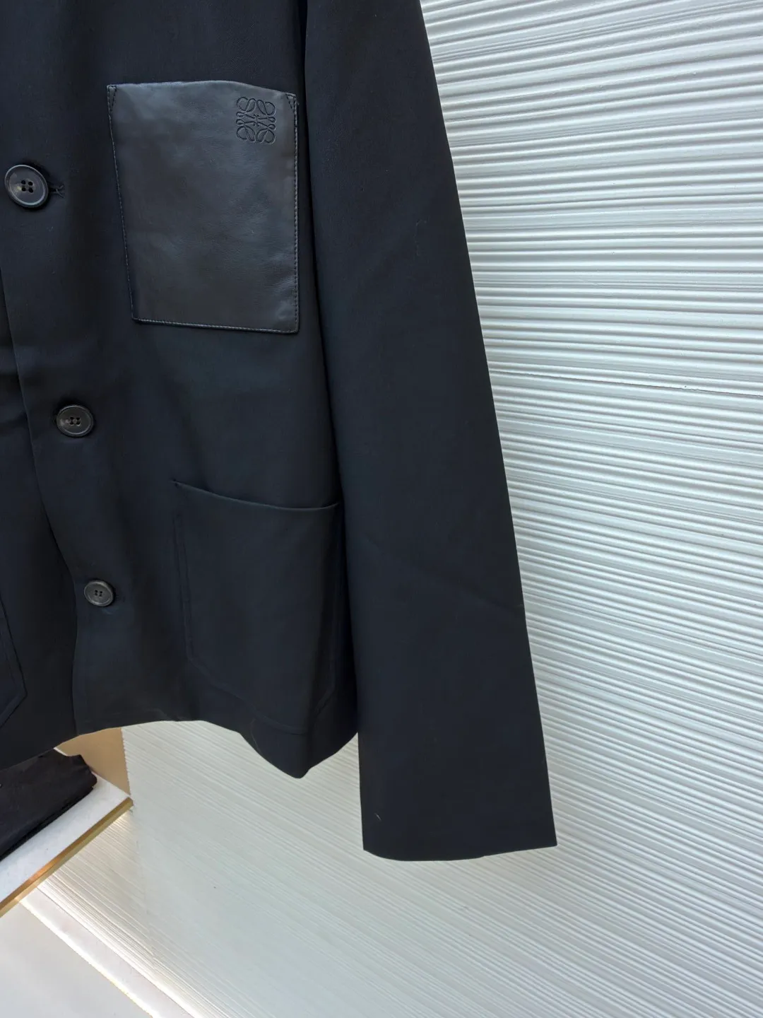 Loewe sheepskin pocket blazer ●Original version: purchased and developed for 17900 ●Item number: 1681610-B40 ●Fabric: wool blended fabric ●Technology: embossed production ●Color: black ●Version: fitted version ●Weight: about 665 grams ●Size: 36-38-40-42 ●Description: 40-count denim wool suit material. This fabric is made of double-layer wool suit fabric with a wool content of up to 55%. Because high-wool fabrics are thin, this fabric is made of double-layer composite. After washing and gluing, the fabric is close to 420 grams. The upper body has a very three-dimensional shape, and the loose fit is also very versatile. The lining is made of Tencel A100+ custom-woven fabric. The pocket leather is cut from soft sheep flat, and the small logo on the leather is pressed out of the original 1:1 positioning mold using a flower machine at a high temperature of 180 degrees. The buttons are made of pure horn buttons. Each real horn button has different textures and scratches. The iconic logo of LOEWE brand is engraved on the surface. The lower pocket has an alloy buckle with the brand's iconic logo. The overall wiring is straight and delicate, the fabric is comfortable and soft, and the color is consistent without color difference. It can be matched with the same style to create a fashionable look and control various occasions. Customized accessories, complete with three standards, same style for men and women!