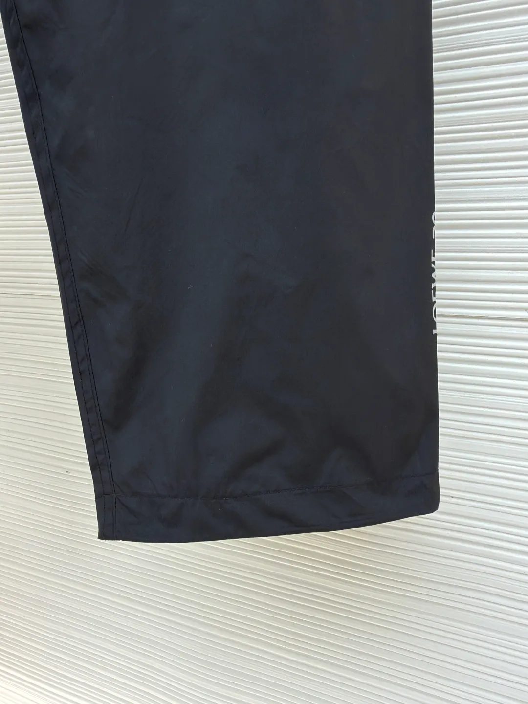 Loewe On co-branded functional sports trousers ●Original version: purchased and developed by 3784 ●Item number: 1681974-B50 ●Fabric: lightweight technical fabric ●Technology: glue printing ●Color: black ●Version: fitted version ●Weight: about 470 grams ●Size: XS-S-M-L ●Description: The main body and lining are made of 100% polyester fiber technical fabric. This synthetic fiber has been specially treated to have core functional properties such as lightweight, high strength, quick-drying and water-repellent, making it ideal for making functional clothing. Mesh lining is used in key areas to significantly improve breathability, accelerate air circulation and avoid stuffiness, thereby providing protection while ensuring comfort. The Anagram On embossed rubber tag on the belt is heat-formed through a mold and is durable, three-dimensional and has a unique tactile feel. The reflective LOEWE On printing on workwear pockets and legs is achieved through a reflective paste printing process. It appears low-key gray under daily light, but when exposed to direct light at night, it will reflect strongly, greatly improving the wearer's visibility and safety in dim environments. The pocket system is the functional core of overalls. The utility flap pockets provide safe storage space and enhance the overall style through a three-dimensional structural design. The multiple side and back waterproof zipper pockets go a step further. By using waterproof taped zippers or laminated waterproof fabrics, important items are absolutely protected from rainwater. The overall wiring is straight and delicate, the fabric is comfortable and soft, and the color is consistent without color difference. It can be matched with the same style to create a fashionable look and control various occasions. Customized accessories, complete with three standards, same style for men and women!