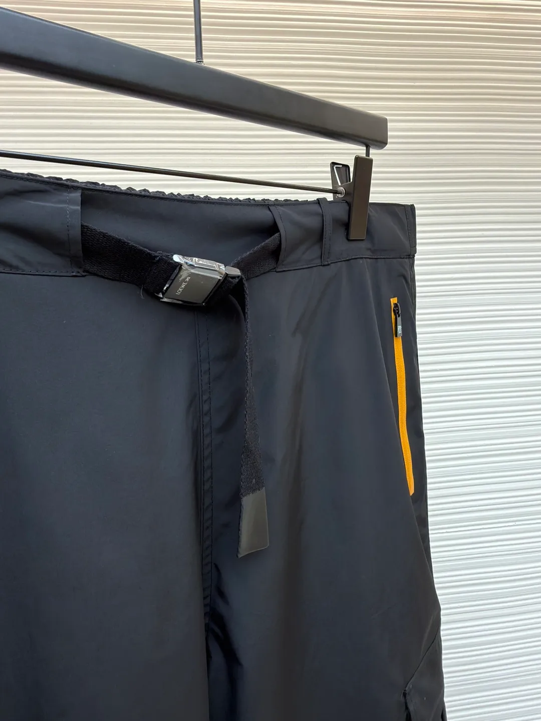 Loewe On co-branded functional sports trousers ●Original version: purchased and developed by 3784 ●Item number: 1681974-B50 ●Fabric: lightweight technical fabric ●Technology: glue printing ●Color: black ●Version: fitted version ●Weight: about 470 grams ●Size: XS-S-M-L ●Description: The main body and lining are made of 100% polyester fiber technical fabric. This synthetic fiber has been specially treated to have core functional properties such as lightweight, high strength, quick-drying and water-repellent, making it ideal for making functional clothing. Mesh lining is used in key areas to significantly improve breathability, accelerate air circulation and avoid stuffiness, thereby providing protection while ensuring comfort. The Anagram On embossed rubber tag on the belt is heat-formed through a mold and is durable, three-dimensional and has a unique tactile feel. The reflective LOEWE On printing on workwear pockets and legs is achieved through a reflective paste printing process. It appears low-key gray under daily light, but when exposed to direct light at night, it will reflect strongly, greatly improving the wearer's visibility and safety in dim environments. The pocket system is the functional core of overalls. The utility flap pockets provide safe storage space and enhance the overall style through a three-dimensional structural design. The multiple side and back waterproof zipper pockets go a step further. By using waterproof taped zippers or laminated waterproof fabrics, important items are absolutely protected from rainwater. The overall wiring is straight and delicate, the fabric is comfortable and soft, and the color is consistent without color difference. It can be matched with the same style to create a fashionable look and control various occasions. Customized accessories, complete with three standards, same style for men and women!