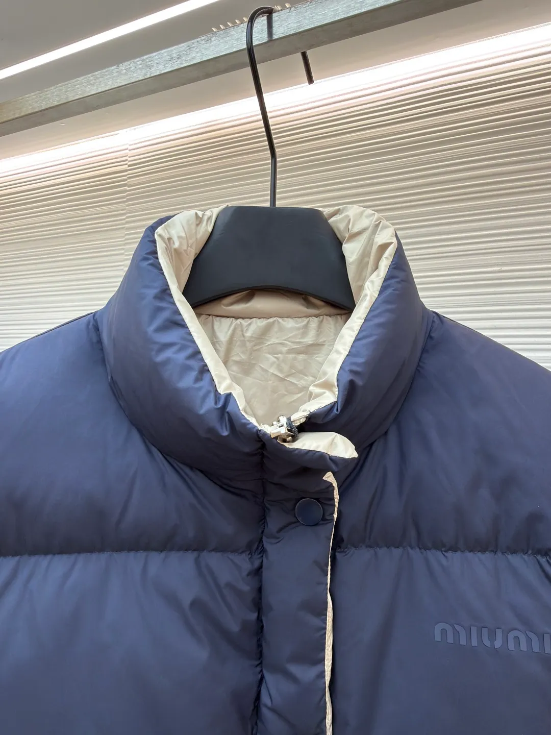 MIUMIU reversible stand collar down jacket ●Original version: purchased and developed by 21060 ●Item number: 1681385-D05 ●Fabric: white duck down fabric ●Technology: mechanical down filling ●Color: navy/khaki ●Version: fitted version ●Weight: about 675 grams ●Size: 36-38-40-42 ●Description: The filling is white duck down with 90% down content, which is one of the gold standards of down quality. "90% down content" means that the down content is extremely high and there are very few impurities such as feather stalks. The down tufts can capture more air and form an efficient thermal insulation layer, thus providing several times the loft and warmth of ordinary down while being lighter in weight. In the double-sided structure, ensuring that the down is evenly distributed between the two layers of fabric without clumping is the core challenge of the down filling process. The stand-up collar design not only improves the neatness of the shape, but also enhances the windproof and warm performance of the neck. Its internal structure needs to be stiff enough to maintain a three-dimensional shape, while at the same time ensuring the comfort of contact with the skin. The precision stitching in conjunction with the overall design not only plays a role in fixing the down and preventing displacement, but the uniformity, tension and pattern of the stitches have become important decorative elements, reflecting rigorous industrial aesthetics. The overall wiring is straight and delicate, the fabric is comfortable and soft, and the color is consistent without color difference. It can be matched with the same style to create a fashionable look and control various occasions. Customized accessories, complete with three standards, same style for men and women!