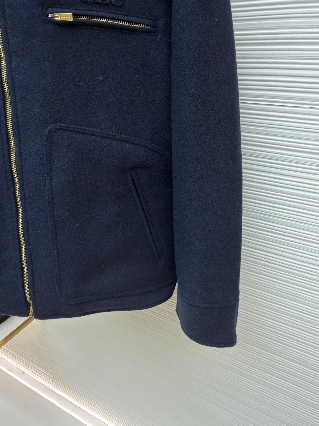 MIUMIU shearling collar embroidered woolen cotton jacket ●Original version: 43702 purchased and developed ●Item number: 1681799-c75 ●Fabric: wool washed fabric ●Technology: laser cutting and shaping ●Color: navy blue ●Version: fitted version ●Weight: about 1440 grams ●Size: 46-48-50-52 ●Description: Made of washed wool fabric treated with special finishing process. The wool fiber becomes more supple through washing, which greatly reduces the irritation that traditional wool may cause, allowing it to be worn directly next to the body with high comfort. At the same time, a uniform and slight velvety layer is formed on the surface. This "distressed" effect gives the fabric a casual, casual, unintentional fashion style, avoiding the overly formal and stiff feeling of traditional wool clothing. The natural elasticity and resilience of wool fiber remain after washing, making the clothes less likely to deform and maintaining a good silhouette for a long time. The letter embroidery patches are laser cut and shaped to create an embossed texture and clear fonts. Each patch undergoes 5 layers of anti-wrinkle treatment to ensure that it retains its original shape after washing, enhancing visual recognition. Using quilted cannage pattern, the seamstress precisely adjusts the speed of the machine and stitch density, so that the stitches are smooth and even during the operation. After completion, regular diagonal quilting lines will be formed, which will inadvertently enhance the overall texture when putting it on and taking it off. The overall wiring is straight and delicate, the fabric is comfortable and soft, and the color is consistent without color difference. It can be matched with the same style to create a fashionable look and control various occasions. Customized accessories, complete with three standards, same style for men and women!