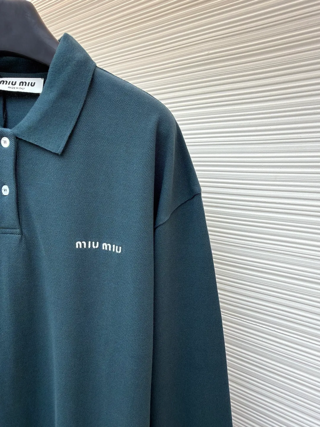 MIUMIU cotton pique POLO shirt ●Original version: purchased and developed at 6890 ●Item number: 1681423-A55 ●Fabric: pique cotton fabric ●Technology: embroidery production ●Color: dark green ●Version: Fitted version ●Weight: about 350 grams ●Size: S-M-L-XL ●Description: This POLO shirt is made of high-density pique cotton fabric, which feels crisp and has good breathability. The POLO collar design uses double-needle hemming + three-dimensional stitching technology to make the collar flat, stylish and fit the neck. The placket buttons are custom-made white pearl buttons, which create a delicate contrast with the dark green fabric. They are sewn with precise alignment for smooth opening and closing. The brand logo on the chest uses high-density embroidery technology, and the letter texture is clear and closely fits the fabric. The cuffs are made of ribbed knitting, which fits the wrist tightly and has excellent elasticity. The overall cut is a loose shoulder-drop version, and the multi-piece structural splicing ensures comfort and freedom when wearing. The length design takes into account both fashion and practicality. The fabric has been dyed through an environmentally friendly dyeing process. The dark green color is uniform and has high color fastness. It is a daily boutique that combines classic POLO styles with high-end embroidery technology. It has both elegant style and wearing comfort. The overall wiring is straight and delicate, the fabric is comfortable and soft, and the color is consistent without color difference. It can be matched with the same style to create a fashionable look and control various occasions. Customized accessories, complete with three standards, same style for men and women!