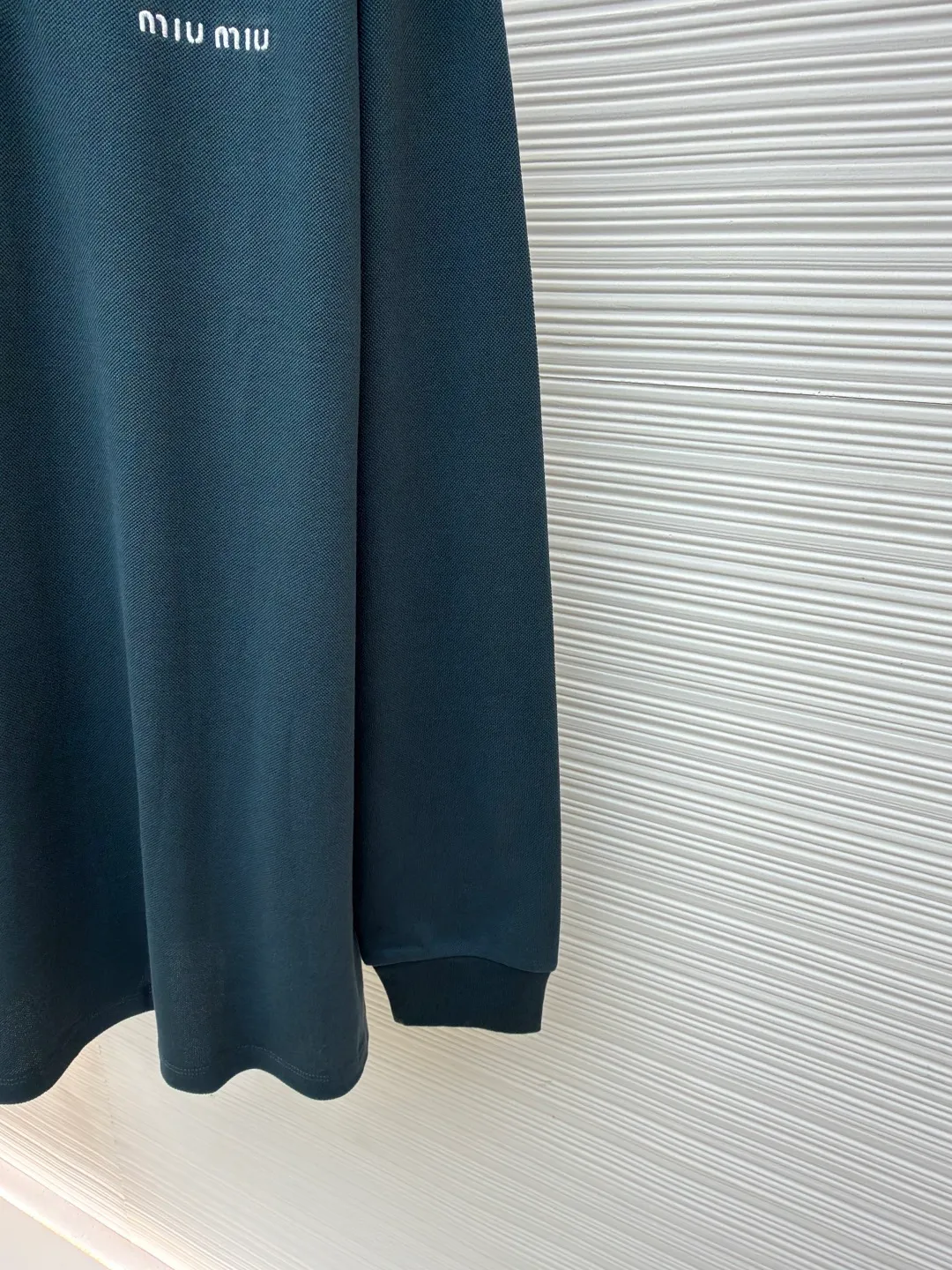 MIUMIU cotton pique POLO shirt ●Original version: purchased and developed at 6890 ●Item number: 1681423-A55 ●Fabric: pique cotton fabric ●Technology: embroidery production ●Color: dark green ●Version: Fitted version ●Weight: about 350 grams ●Size: S-M-L-XL ●Description: This POLO shirt is made of high-density pique cotton fabric, which feels crisp and has good breathability. The POLO collar design uses double-needle hemming + three-dimensional stitching technology to make the collar flat, stylish and fit the neck. The placket buttons are custom-made white pearl buttons, which create a delicate contrast with the dark green fabric. They are sewn with precise alignment for smooth opening and closing. The brand logo on the chest uses high-density embroidery technology, and the letter texture is clear and closely fits the fabric. The cuffs are made of ribbed knitting, which fits the wrist tightly and has excellent elasticity. The overall cut is a loose shoulder-drop version, and the multi-piece structural splicing ensures comfort and freedom when wearing. The length design takes into account both fashion and practicality. The fabric has been dyed through an environmentally friendly dyeing process. The dark green color is uniform and has high color fastness. It is a daily boutique that combines classic POLO styles with high-end embroidery technology. It has both elegant style and wearing comfort. The overall wiring is straight and delicate, the fabric is comfortable and soft, and the color is consistent without color difference. It can be matched with the same style to create a fashionable look and control various occasions. Customized accessories, complete with three standards, same style for men and women!