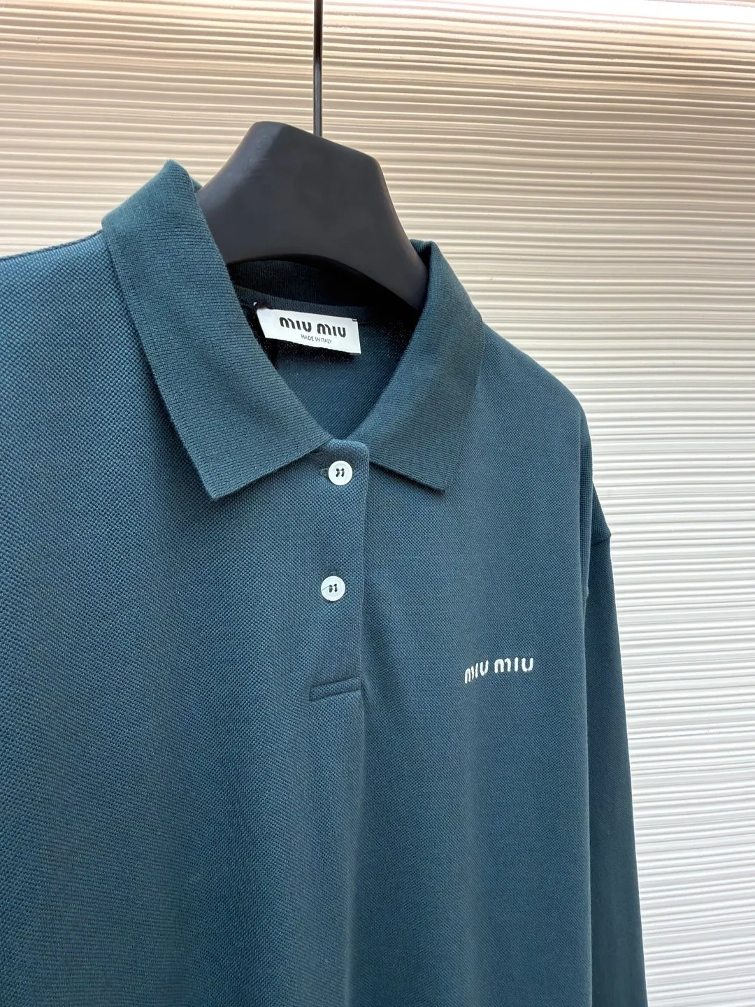 MIUMIU cotton pique POLO shirt ●Original version: purchased and developed at 6890 ●Item number: 1681423-A55 ●Fabric: pique cotton fabric ●Technology: embroidery production ●Color: dark green ●Version: Fitted version ●Weight: about 350 grams ●Size: S-M-L-XL ●Description: This POLO shirt is made of high-density pique cotton fabric, which feels crisp and has good breathability. The POLO collar design uses double-needle hemming + three-dimensional stitching technology to make the collar flat, stylish and fit the neck. The placket buttons are custom-made white pearl buttons, which create a delicate contrast with the dark green fabric. They are sewn with precise alignment for smooth opening and closing. The brand logo on the chest uses high-density embroidery technology, and the letter texture is clear and closely fits the fabric. The cuffs are made of ribbed knitting, which fits the wrist tightly and has excellent elasticity. The overall cut is a loose shoulder-drop version, and the multi-piece structural splicing ensures comfort and freedom when wearing. The length design takes into account both fashion and practicality. The fabric has been dyed through an environmentally friendly dyeing process. The dark green color is uniform and has high color fastness. It is a daily boutique that combines classic POLO styles with high-end embroidery technology. It has both elegant style and wearing comfort. The overall wiring is straight and delicate, the fabric is comfortable and soft, and the color is consistent without color difference. It can be matched with the same style to create a fashionable look and control various occasions. Customized accessories, complete with three standards, same style for men and women!