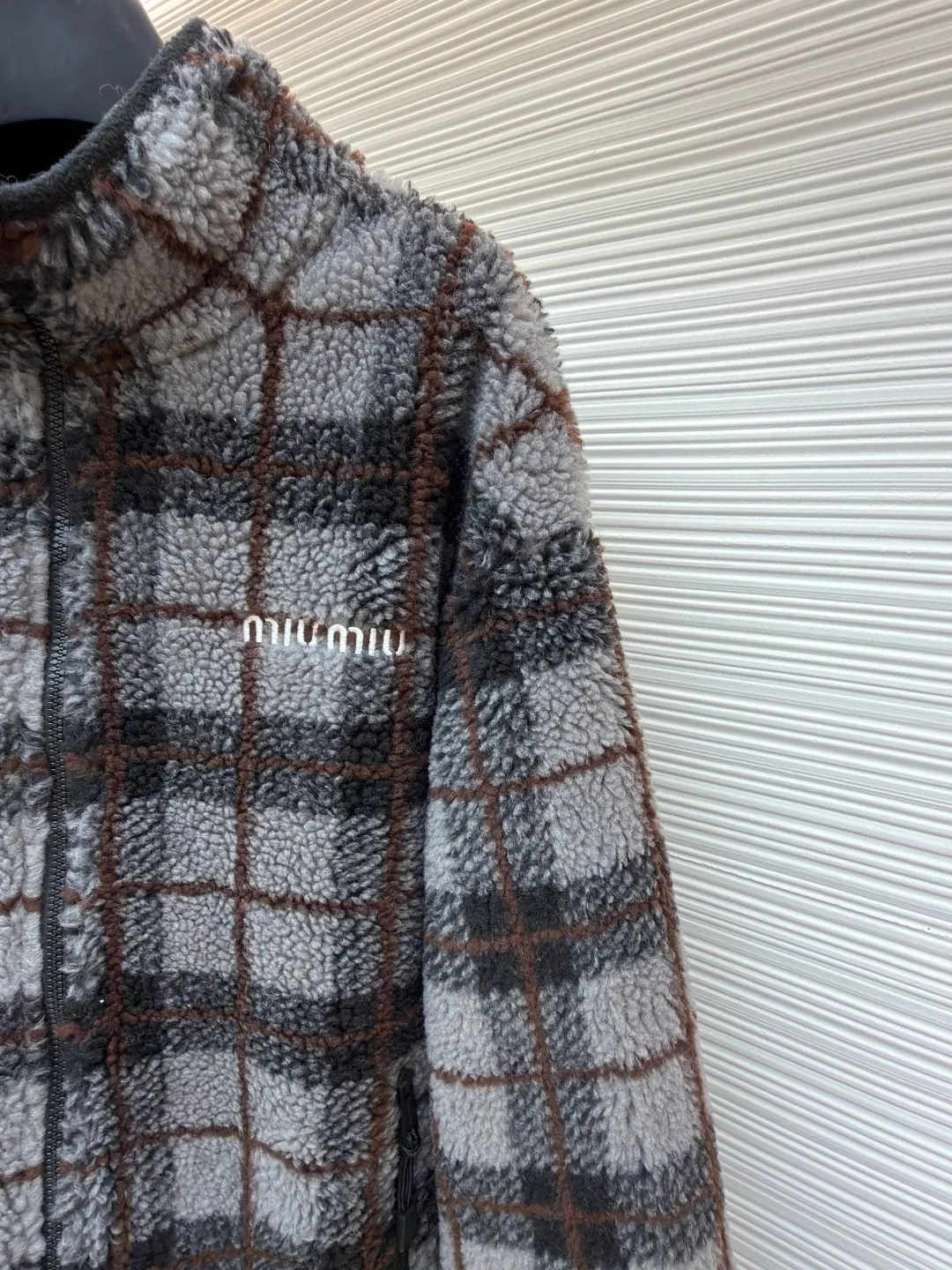 MIUMIU sherpa plaid embroidered zipper jacket ●Original version: Purchased and developed in 20100 ●Item number: 1682023-B25 ●Fabric: wool fabric ●Technology: embroidery production ●Color: gray ●Type: fitted version ●Weight: about 770 grams ●Size: S-M-L-XL ●Description: Made of 80% wool, 20% cotton. This fabric is originally woven and dyed, 100% restored. The lining pocket fabric is made of 100% nylon material and the back collar is matched with 100% wool teddy fleece. The zipper is made of nylon and rubber teeth, and the pull teeth are made of European rubber teeth. The hem has an original engraved elastic buckle. The embroidery adopts 3D three-dimensional embroidery technology, and the embroidered logo is full and three-dimensional. Presenting high-end visual effects. The classic jacket is reinterpreted here, with wool added for added thickness and softness. The classic plaid pattern draws inspiration from menswear style, reinterpreting the style code of sporty femininity. Oversize version. Unlined long-sleeved stand collar. Front zippered side pockets. Double-ended crochet hem. Embroidered logo. The overall wiring is straight and delicate, the fabric is comfortable and soft, and the color is consistent without color difference. It can be matched with the same style to create a fashionable look and control various occasions. Customized accessories, complete with three standards, same style for men and women!