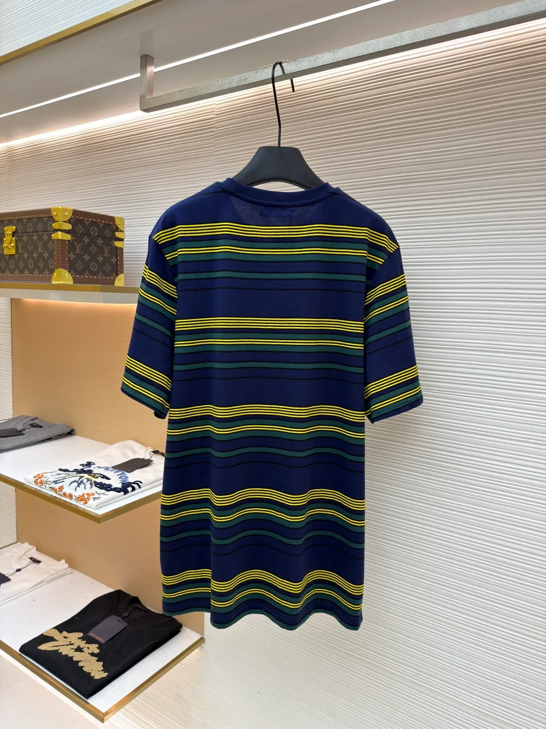 MIUMIU yellow, green and blue striped round neck short sleeves ●Original version: purchased and developed by 4755 ●Item number: 1681739-A10 ●Fabric: Jacquard striped knitted fabric ●Technology: Wool jacquard production ●Color: yellow, green and blue ●Version: Fitted version ●Weight: about 185 grams ●Size: XS-S-M-L ●Description: Using 32S jacquard stripe technology special textile compact cotton , 145g; with 32S double yarn frame, 380g. The fabric is made of 32-count combed cotton yarn and has been processed by compact spinning technology, so that the yarn fibers are tightly arranged and impurities and hairiness are significantly reduced. The fabric structure is denser and smoother. It not only feels delicate and smooth, but its wear resistance and anti-pilling performance is also far superior to ordinary cotton fabrics. The weight of the fabric ensures that the fabric has good durability while maintaining the natural breathability and skin-friendly properties of cotton. It is very suitable for spring, summer and transitional seasons, and achieves the unity of comfort and quality. The striped effect is achieved through plain knitting technology where colored yarns are alternately woven. This is different from later printing. The color is firm and long-lasting, and the striped edges are clear and neat. The design that combines simple stripes with the possible jacquard texture of the underlying fabric increases the visual layering, avoids monotony, and embodies the design idea of ​​finding sophistication in simplicity. The wool jacquard logo process is a high-end technology that weaves the brand logo directly into the fabric. The warp and weft yarns of the loom are controlled by computer programming, and yarns of different colors are interwoven to form precise and clear patterns on the surface of the sweater. The jacquard process makes the logo and logo fabric seamlessly integrated, with a smooth touch and no bulges, and clear and seamless edges, which greatly improves wearing comfort and aesthetics. The overall wiring is straight and delicate, the fabric is comfortable and soft, and the color is consistent without color difference. It can be matched with the same style to create a fashionable look and control various occasions. Customized accessories, complete with three standards, same style for men and women!