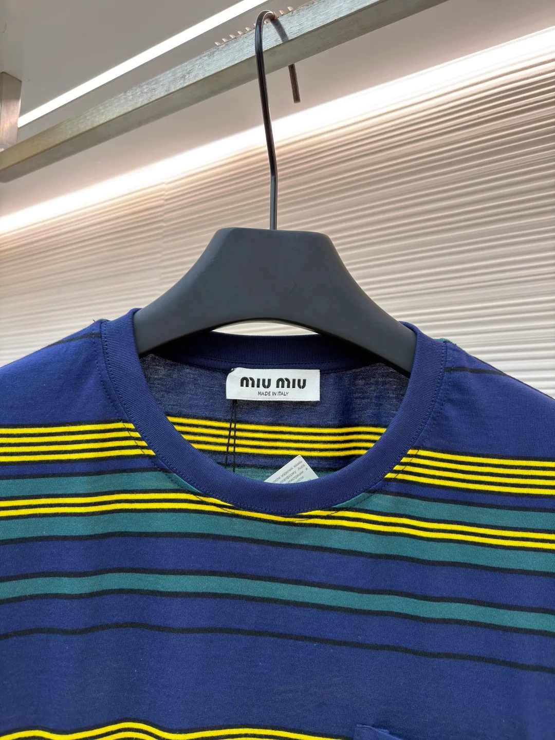 MIUMIU yellow, green and blue striped round neck short sleeves ●Original version: purchased and developed by 4755 ●Item number: 1681739-A10 ●Fabric: Jacquard striped knitted fabric ●Technology: Wool jacquard production ●Color: yellow, green and blue ●Version: Fitted version ●Weight: about 185 grams ●Size: XS-S-M-L ●Description: Using 32S jacquard stripe technology special textile compact cotton , 145g; with 32S double yarn frame, 380g. The fabric is made of 32-count combed cotton yarn and has been processed by compact spinning technology, so that the yarn fibers are tightly arranged and impurities and hairiness are significantly reduced. The fabric structure is denser and smoother. It not only feels delicate and smooth, but its wear resistance and anti-pilling performance is also far superior to ordinary cotton fabrics. The weight of the fabric ensures that the fabric has good durability while maintaining the natural breathability and skin-friendly properties of cotton. It is very suitable for spring, summer and transitional seasons, and achieves the unity of comfort and quality. The striped effect is achieved through plain knitting technology where colored yarns are alternately woven. This is different from later printing. The color is firm and long-lasting, and the striped edges are clear and neat. The design that combines simple stripes with the possible jacquard texture of the underlying fabric increases the visual layering, avoids monotony, and embodies the design idea of ​​finding sophistication in simplicity. The wool jacquard logo process is a high-end technology that weaves the brand logo directly into the fabric. The warp and weft yarns of the loom are controlled by computer programming, and yarns of different colors are interwoven to form precise and clear patterns on the surface of the sweater. The jacquard process makes the logo and logo fabric seamlessly integrated, with a smooth touch and no bulges, and clear and seamless edges, which greatly improves wearing comfort and aesthetics. The overall wiring is straight and delicate, the fabric is comfortable and soft, and the color is consistent without color difference. It can be matched with the same style to create a fashionable look and control various occasions. Customized accessories, complete with three standards, same style for men and women!