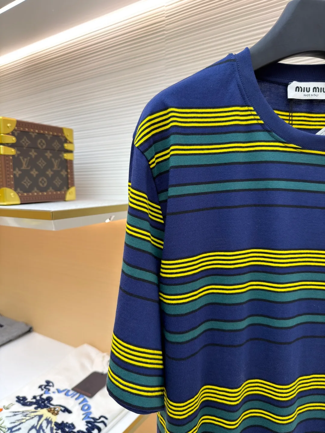 MIUMIU yellow, green and blue striped round neck short sleeves ●Original version: purchased and developed by 4755 ●Item number: 1681739-A10 ●Fabric: Jacquard striped knitted fabric ●Technology: Wool jacquard production ●Color: yellow, green and blue ●Version: Fitted version ●Weight: about 185 grams ●Size: XS-S-M-L ●Description: Using 32S jacquard stripe technology special textile compact cotton , 145g; with 32S double yarn frame, 380g. The fabric is made of 32-count combed cotton yarn and has been processed by compact spinning technology, so that the yarn fibers are tightly arranged and impurities and hairiness are significantly reduced. The fabric structure is denser and smoother. It not only feels delicate and smooth, but its wear resistance and anti-pilling performance is also far superior to ordinary cotton fabrics. The weight of the fabric ensures that the fabric has good durability while maintaining the natural breathability and skin-friendly properties of cotton. It is very suitable for spring, summer and transitional seasons, and achieves the unity of comfort and quality. The striped effect is achieved through plain knitting technology where colored yarns are alternately woven. This is different from later printing. The color is firm and long-lasting, and the striped edges are clear and neat. The design that combines simple stripes with the possible jacquard texture of the underlying fabric increases the visual layering, avoids monotony, and embodies the design idea of ​​finding sophistication in simplicity. The wool jacquard logo process is a high-end technology that weaves the brand logo directly into the fabric. The warp and weft yarns of the loom are controlled by computer programming, and yarns of different colors are interwoven to form precise and clear patterns on the surface of the sweater. The jacquard process makes the logo and logo fabric seamlessly integrated, with a smooth touch and no bulges, and clear and seamless edges, which greatly improves wearing comfort and aesthetics. The overall wiring is straight and delicate, the fabric is comfortable and soft, and the color is consistent without color difference. It can be matched with the same style to create a fashionable look and control various occasions. Customized accessories, complete with three standards, same style for men and women!