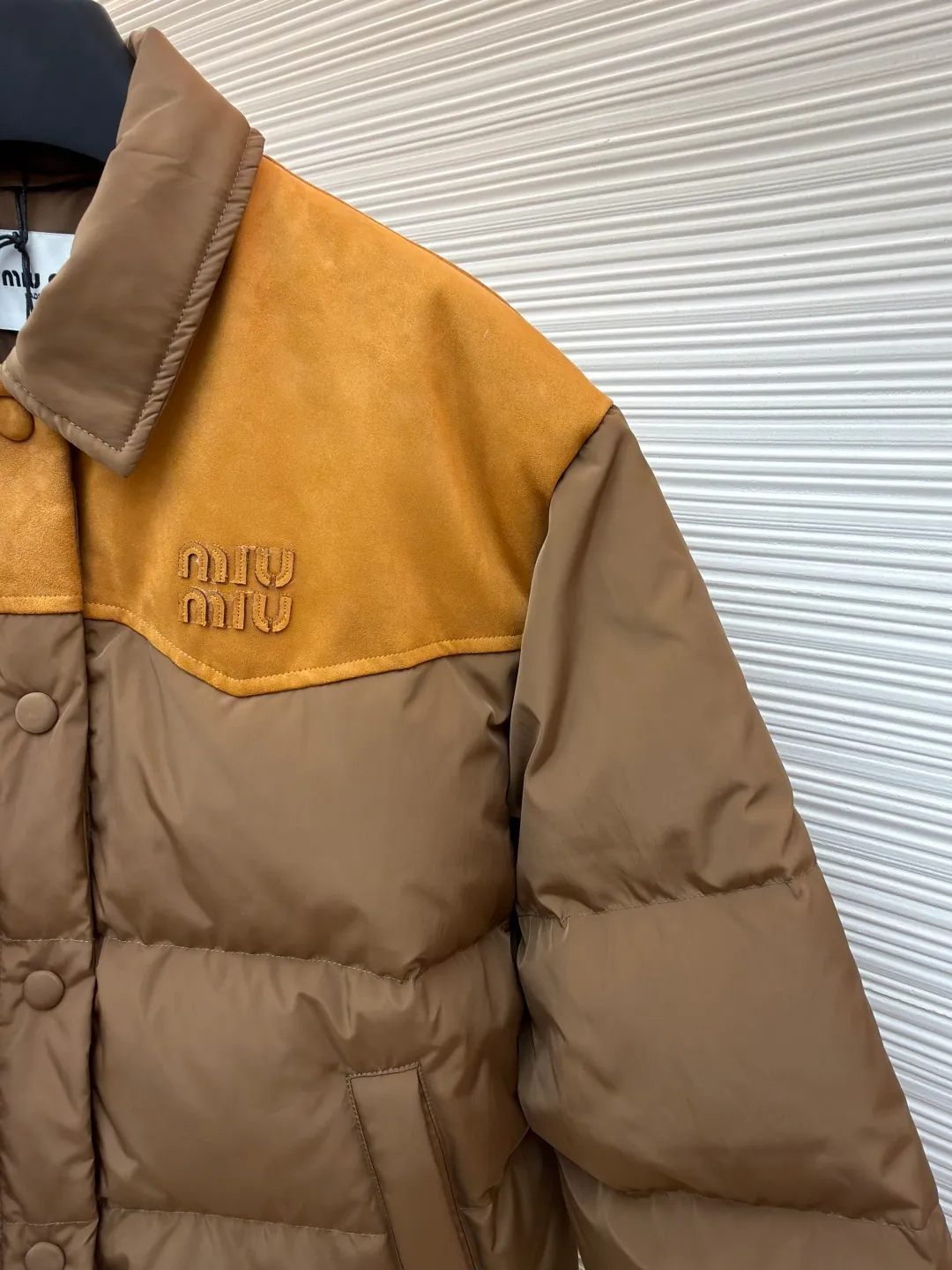 MIUMIU flocked splicing lapel down jacket ●Original version: Purchased and developed for 23599 ●Item number: 1681920-C10 ●Fabric: white duck down fabric ●Technology: embossed flocking ●Color: brown ●Version: fitted version ●Weight: about 695 grams ●Size: S-M-L ●Description: This style is Miu Miu-style spliced down jacket uses collision splicing technology: the main body is made of high-density matte nylon fabric, which is wind-resistant and anti-sand velvet; the collar and front chest area are spliced with fine suede, and the diagonal stitching is used to enhance the texture contrast. The filling is made of high-fill white duck down, and the segmented down filling process ensures an even amount of down in each grid, with a fill power of 600+; the placket is designed with metal snaps and a built-in concealed buckle for double temperature locking. The "MIU MIU" logo on the front chest adopts embossed flocking technology, which has a three-dimensional touch and is not easy to fall off; the cuffs and hem are elasticized to fit the body shape. The overall stitching uses anti-drilling velvet hemming needles, and the pockets are obliquely inserted invisible pockets, taking into account both beauty and practicality. It is a fashionable style that is lightweight and warm in autumn and winter. The overall wiring is straight and delicate, the fabric is comfortable and soft, and the color is consistent without color difference. It can be matched with the same style to create a fashionable look and control various occasions. Customized accessories, complete with three standards, same style for men and women!