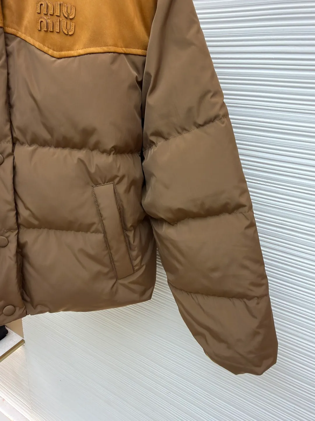 MIUMIU flocked splicing lapel down jacket ●Original version: Purchased and developed for 23599 ●Item number: 1681920-C10 ●Fabric: white duck down fabric ●Technology: embossed flocking ●Color: brown ●Version: fitted version ●Weight: about 695 grams ●Size: S-M-L ●Description: This style is Miu Miu-style spliced down jacket uses collision splicing technology: the main body is made of high-density matte nylon fabric, which is wind-resistant and anti-sand velvet; the collar and front chest area are spliced with fine suede, and the diagonal stitching is used to enhance the texture contrast. The filling is made of high-fill white duck down, and the segmented down filling process ensures an even amount of down in each grid, with a fill power of 600+; the placket is designed with metal snaps and a built-in concealed buckle for double temperature locking. The "MIU MIU" logo on the front chest adopts embossed flocking technology, which has a three-dimensional touch and is not easy to fall off; the cuffs and hem are elasticized to fit the body shape. The overall stitching uses anti-drilling velvet hemming needles, and the pockets are obliquely inserted invisible pockets, taking into account both beauty and practicality. It is a fashionable style that is lightweight and warm in autumn and winter. The overall wiring is straight and delicate, the fabric is comfortable and soft, and the color is consistent without color difference. It can be matched with the same style to create a fashionable look and control various occasions. Customized accessories, complete with three standards, same style for men and women!