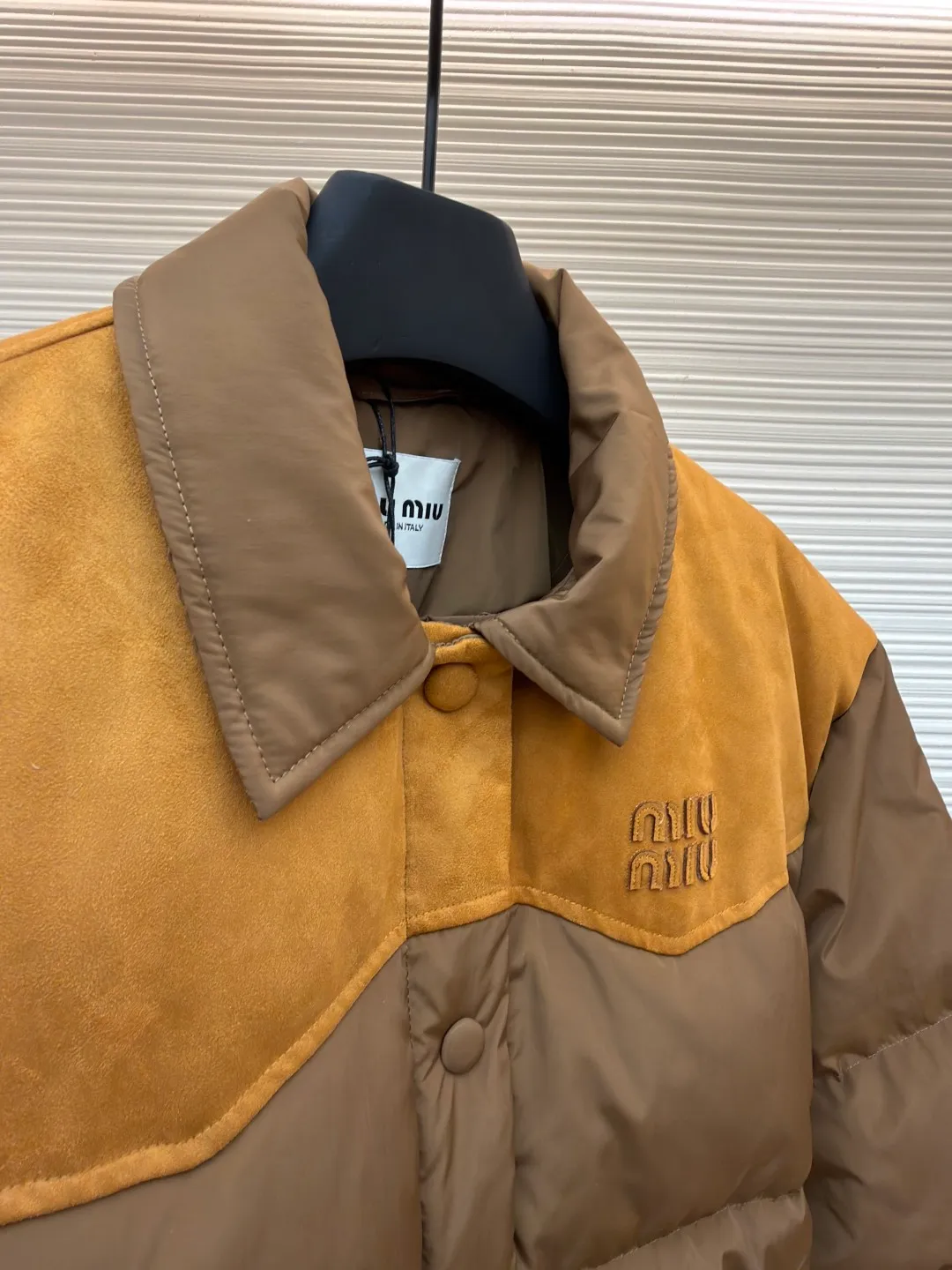 MIUMIU flocked splicing lapel down jacket ●Original version: Purchased and developed for 23599 ●Item number: 1681920-C10 ●Fabric: white duck down fabric ●Technology: embossed flocking ●Color: brown ●Version: fitted version ●Weight: about 695 grams ●Size: S-M-L ●Description: This style is Miu Miu-style spliced down jacket uses collision splicing technology: the main body is made of high-density matte nylon fabric, which is wind-resistant and anti-sand velvet; the collar and front chest area are spliced with fine suede, and the diagonal stitching is used to enhance the texture contrast. The filling is made of high-fill white duck down, and the segmented down filling process ensures an even amount of down in each grid, with a fill power of 600+; the placket is designed with metal snaps and a built-in concealed buckle for double temperature locking. The "MIU MIU" logo on the front chest adopts embossed flocking technology, which has a three-dimensional touch and is not easy to fall off; the cuffs and hem are elasticized to fit the body shape. The overall stitching uses anti-drilling velvet hemming needles, and the pockets are obliquely inserted invisible pockets, taking into account both beauty and practicality. It is a fashionable style that is lightweight and warm in autumn and winter. The overall wiring is straight and delicate, the fabric is comfortable and soft, and the color is consistent without color difference. It can be matched with the same style to create a fashionable look and control various occasions. Customized accessories, complete with three standards, same style for men and women!