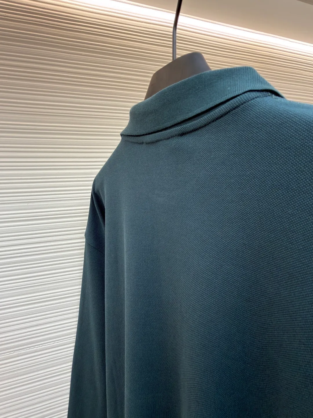MIUMIU cotton pique POLO shirt ●Original version: purchased and developed at 6890 ●Item number: 1681423-A55 ●Fabric: pique cotton fabric ●Technology: embroidery production ●Color: dark green ●Version: Fitted version ●Weight: about 350 grams ●Size: S-M-L-XL ●Description: This POLO shirt is made of high-density pique cotton fabric, which feels crisp and has good breathability. The POLO collar design uses double-needle hemming + three-dimensional stitching technology to make the collar flat, stylish and fit the neck. The placket buttons are custom-made white pearl buttons, which create a delicate contrast with the dark green fabric. They are sewn with precise alignment for smooth opening and closing. The brand logo on the chest uses high-density embroidery technology, and the letter texture is clear and closely fits the fabric. The cuffs are made of ribbed knitting, which fits the wrist tightly and has excellent elasticity. The overall cut is a loose shoulder-drop version, and the multi-piece structural splicing ensures comfort and freedom when wearing. The length design takes into account both fashion and practicality. The fabric has been dyed through an environmentally friendly dyeing process. The dark green color is uniform and has high color fastness. It is a daily boutique that combines classic POLO styles with high-end embroidery technology. It has both elegant style and wearing comfort. The overall wiring is straight and delicate, the fabric is comfortable and soft, and the color is consistent without color difference. It can be matched with the same style to create a fashionable look and control various occasions. Customized accessories, complete with three standards, same style for men and women!