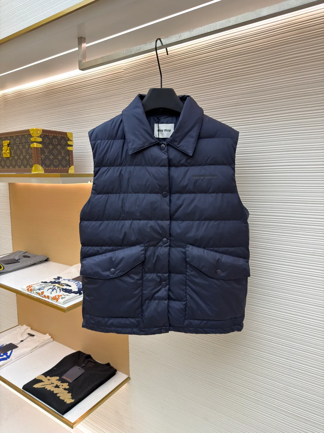 MIUMIU rib down lapel vest ●Original version: Purchased and developed for 12999 ●Item number: 1681785-C05 ●Fabric: goose down fabric ●Technology: mechanical down filling ●Color: navy blue ●Version: fitted version ●Weight: about 350 grams ●Size: 36-38-40-42 ●Description: Down anti-drilling liner is a kind of inner liner specially used for down jackets. It is usually made of high-density, anti-drilling down and good breathability materials. It can effectively prevent down from drilling out while maintaining the warmth and breathability of down jackets. Goose down filling is a high-quality filling in down jackets. It is rich in down, and because goose down has a higher loft, it can lock in more air, making the down jacket warmer. Down is soft and delicate. It feels soft and comfortable when worn on the human body, without the foreign body feeling caused by other fillings. After aurora printing, the pattern containing special additives is heat-pressed and transferred to the fabric in the form of a film, and the process parameters are adjusted to give it a slightly aged texture. This not only achieves the decorative purpose of the brand logo, but also avoids the stiffness often found in new technology fabrics because of its retro treatment of details. The design of the shirt collar allows the vest to increase its versatility. The snap closure provides a faster, smoother and more even force-on and take-off experience, especially when worn as an inner layer, making it less likely to snag with outer clothing. The elastic drawstring hem can be tightened by the drawstring, effectively preventing cold air from pouring in from the bottom and locking in body heat. The flap pocket is a classic outdoor functional design that prevents rain, wind and snow from entering the pocket, and is equipped with buttons for a more durable and quieter closure.