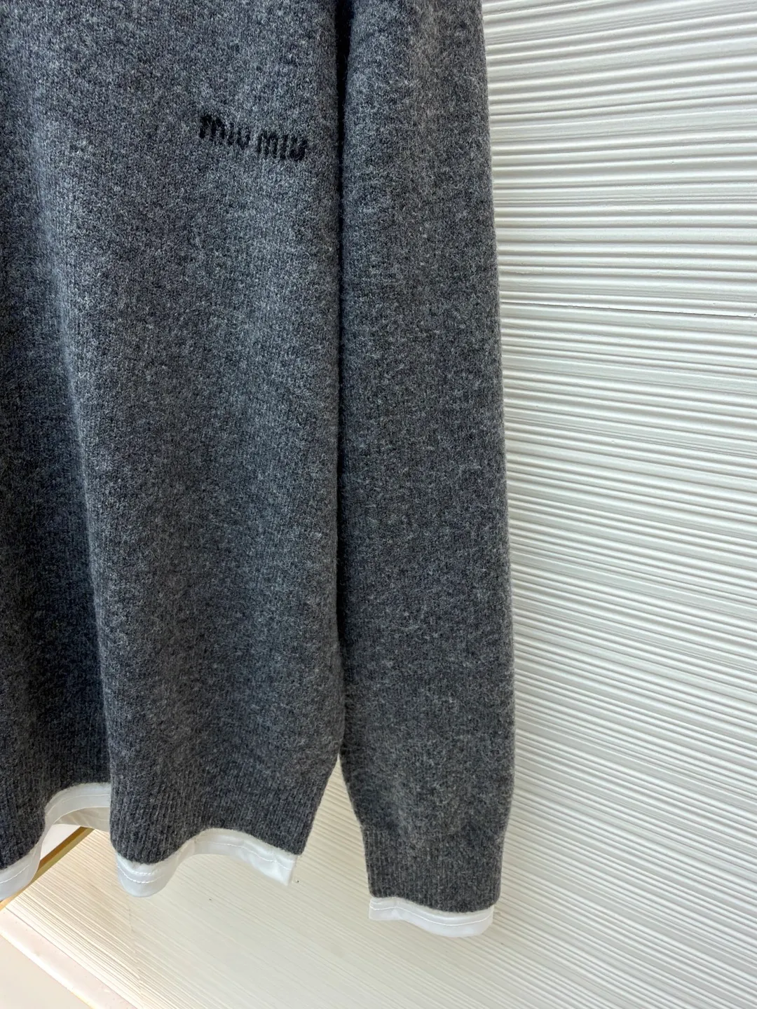 MIUMIU fake two-piece V-neck cashmere sweater ●Original version: purchased and developed in 20300 ●Item number: 1681164-A95 ●Fabric: cashmere fabric ●Technology: knitted ●Color: gray ●Version: fitted version ●Weight: about 625 grams ●Size: S-M-L-XL ●Description: Miu style logo and contrasting fake two pieces are gathered into one piece. The cuffs, collar and tail are spliced with pure cotton fabric to highlight the sense of layering. It is a personalized interpretation that interprets the sense of layering from a modern perspective to create a playful look and freedom. The overall wiring is straight and delicate, the fabric is comfortable and soft, and the color is consistent without color difference. It can be matched with the same style to create a fashionable look and control various occasions. Customized accessories, complete with three standards, same style for men and women!