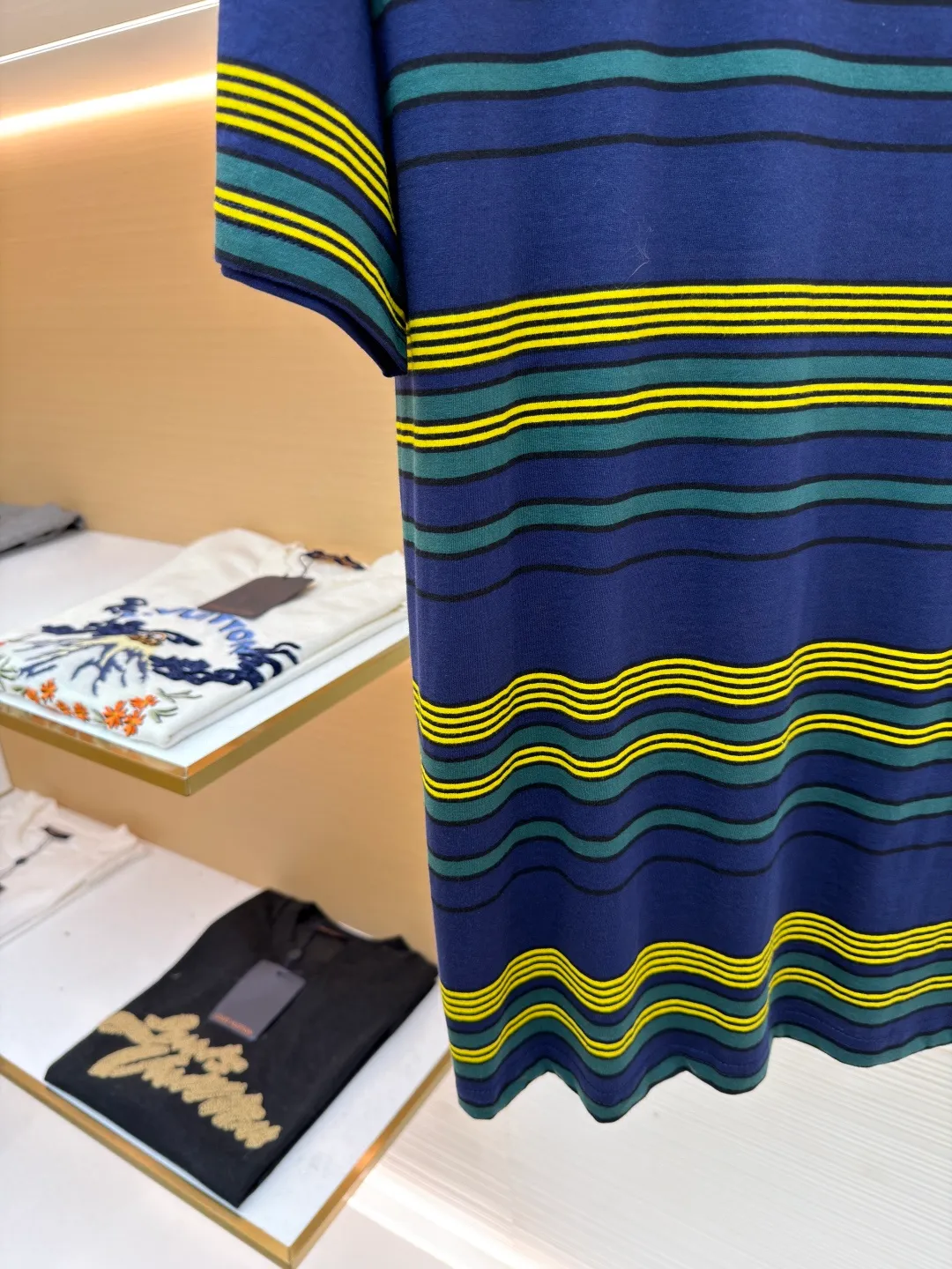 MIUMIU yellow, green and blue striped round neck short sleeves ●Original version: purchased and developed by 4755 ●Item number: 1681739-A10 ●Fabric: Jacquard striped knitted fabric ●Technology: Wool jacquard production ●Color: yellow, green and blue ●Version: Fitted version ●Weight: about 185 grams ●Size: XS-S-M-L ●Description: Using 32S jacquard stripe technology special textile compact cotton , 145g; with 32S double yarn frame, 380g. The fabric is made of 32-count combed cotton yarn and has been processed by compact spinning technology, so that the yarn fibers are tightly arranged and impurities and hairiness are significantly reduced. The fabric structure is denser and smoother. It not only feels delicate and smooth, but its wear resistance and anti-pilling performance is also far superior to ordinary cotton fabrics. The weight of the fabric ensures that the fabric has good durability while maintaining the natural breathability and skin-friendly properties of cotton. It is very suitable for spring, summer and transitional seasons, and achieves the unity of comfort and quality. The striped effect is achieved through plain knitting technology where colored yarns are alternately woven. This is different from later printing. The color is firm and long-lasting, and the striped edges are clear and neat. The design that combines simple stripes with the possible jacquard texture of the underlying fabric increases the visual layering, avoids monotony, and embodies the design idea of ​​finding sophistication in simplicity. The wool jacquard logo process is a high-end technology that weaves the brand logo directly into the fabric. The warp and weft yarns of the loom are controlled by computer programming, and yarns of different colors are interwoven to form precise and clear patterns on the surface of the sweater. The jacquard process makes the logo and logo fabric seamlessly integrated, with a smooth touch and no bulges, and clear and seamless edges, which greatly improves wearing comfort and aesthetics. The overall wiring is straight and delicate, the fabric is comfortable and soft, and the color is consistent without color difference. It can be matched with the same style to create a fashionable look and control various occasions. Customized accessories, complete with three standards, same style for men and women!