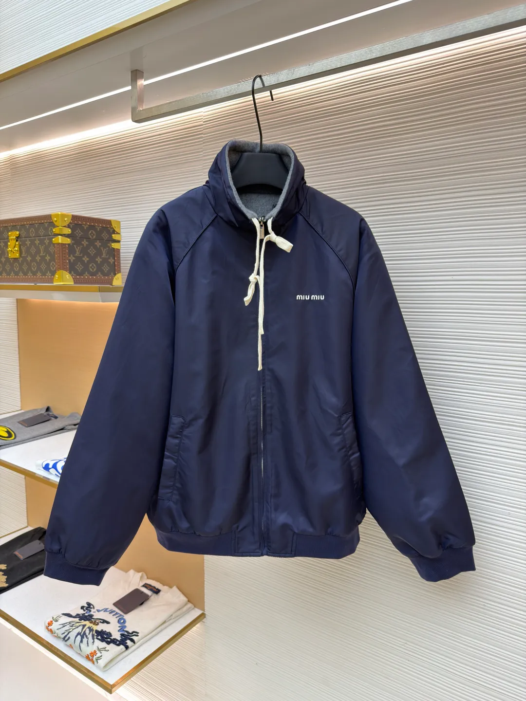 MIUMIU reversible technical fabric and fleece jacket ●Original version: 28200 purchase and development ●Item number: 1682256-C00 ●Fabric: wool blended anti-static plush fabric ●Technology: high temperature pre-shrunk production ●Color: blue/grey ●Version: fitted version ●Weight: about 890 grams ●Size: 36-38-40-42 ●Description: This Miu The Miu navy jacket is made of high-density polyester fabric, which has been treated with water-repellent treatment. The surface has a fine matte texture and has good windproof performance. The body is cut with raglan sleeves, and the three-dimensional patterning technology is used to make the shoulder lines more ergonomic, and there is no sense of restraint when moving. The neckline is spliced ​​with gray fleece lining, which is reinforced with double-needle hemming technology. The drawstring is made of natural cotton rope and has been brushed. The texture is soft and waxy and not easy to deform. The front is equipped with a customized metal zipper, and the smoothness of the gear rail has been tested multiple times. The zipper puller and brand logo are both made by laser engraving. The ribbed edges on the hem and cuffs are made of spandex blended material and are pre-shrunk to prevent them from loosening after long-term wear. The overall stitching uses dual processes of flat turning and overlocking. The stitching is even and fine, reaching the high standard of 12 stitches per inch, ensuring both a stiff silhouette and durability. The overall wiring is straight and delicate, the fabric is comfortable and soft, and the color is consistent without color difference. It can be matched with the same style to create a fashionable look and control various occasions. Customized accessories, complete with three standards, same style for men and women!