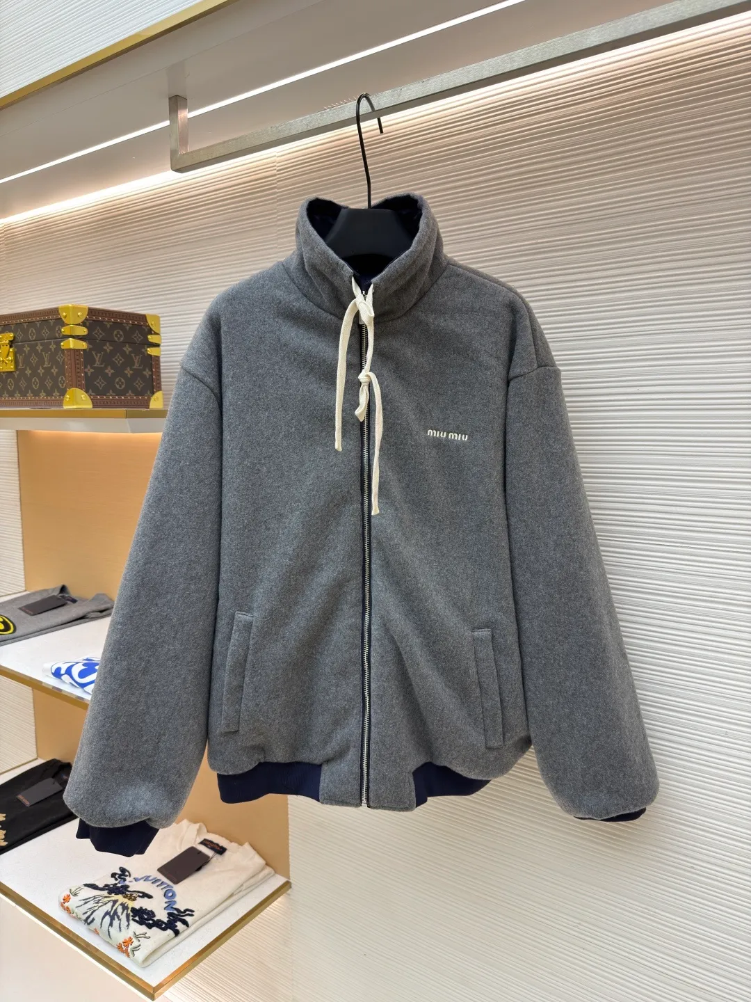 MIUMIU reversible technical fabric and fleece jacket ●Original version: 28200 purchase and development ●Item number: 1682256-C00 ●Fabric: wool blended anti-static plush fabric ●Technology: high temperature pre-shrunk production ●Color: blue/grey ●Version: fitted version ●Weight: about 890 grams ●Size: 36-38-40-42 ●Description: This Miu The Miu navy jacket is made of high-density polyester fabric, which has been treated with water-repellent treatment. The surface has a fine matte texture and has good windproof performance. The body is cut with raglan sleeves, and the three-dimensional patterning technology is used to make the shoulder lines more ergonomic, and there is no sense of restraint when moving. The neckline is spliced ​​with gray fleece lining, which is reinforced with double-needle hemming technology. The drawstring is made of natural cotton rope and has been brushed. The texture is soft and waxy and not easy to deform. The front is equipped with a customized metal zipper, and the smoothness of the gear rail has been tested multiple times. The zipper puller and brand logo are both made by laser engraving. The ribbed edges on the hem and cuffs are made of spandex blended material and are pre-shrunk to prevent them from loosening after long-term wear. The overall stitching uses dual processes of flat turning and overlocking. The stitching is even and fine, reaching the high standard of 12 stitches per inch, ensuring both a stiff silhouette and durability. The overall wiring is straight and delicate, the fabric is comfortable and soft, and the color is consistent without color difference. It can be matched with the same style to create a fashionable look and control various occasions. Customized accessories, complete with three standards, same style for men and women!