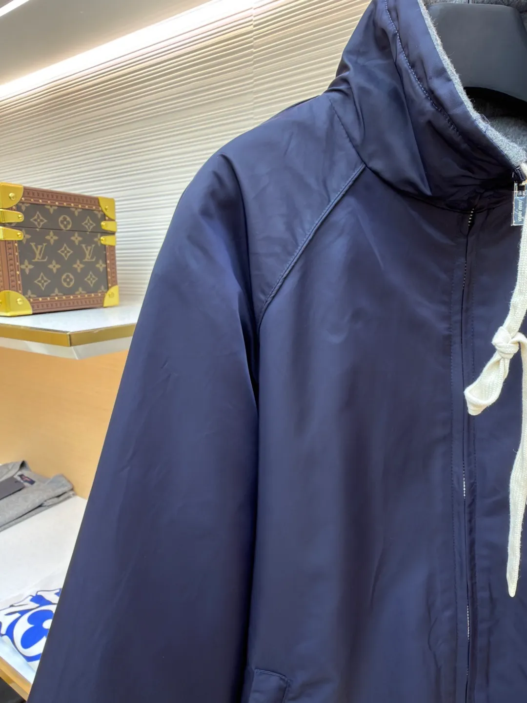 MIUMIU reversible technical fabric and fleece jacket ●Original version: 28200 purchase and development ●Item number: 1682256-C00 ●Fabric: wool blended anti-static plush fabric ●Technology: high temperature pre-shrunk production ●Color: blue/grey ●Version: fitted version ●Weight: about 890 grams ●Size: 36-38-40-42 ●Description: This Miu The Miu navy jacket is made of high-density polyester fabric, which has been treated with water-repellent treatment. The surface has a fine matte texture and has good windproof performance. The body is cut with raglan sleeves, and the three-dimensional patterning technology is used to make the shoulder lines more ergonomic, and there is no sense of restraint when moving. The neckline is spliced ​​with gray fleece lining, which is reinforced with double-needle hemming technology. The drawstring is made of natural cotton rope and has been brushed. The texture is soft and waxy and not easy to deform. The front is equipped with a customized metal zipper, and the smoothness of the gear rail has been tested multiple times. The zipper puller and brand logo are both made by laser engraving. The ribbed edges on the hem and cuffs are made of spandex blended material and are pre-shrunk to prevent them from loosening after long-term wear. The overall stitching uses dual processes of flat turning and overlocking. The stitching is even and fine, reaching the high standard of 12 stitches per inch, ensuring both a stiff silhouette and durability. The overall wiring is straight and delicate, the fabric is comfortable and soft, and the color is consistent without color difference. It can be matched with the same style to create a fashionable look and control various occasions. Customized accessories, complete with three standards, same style for men and women!