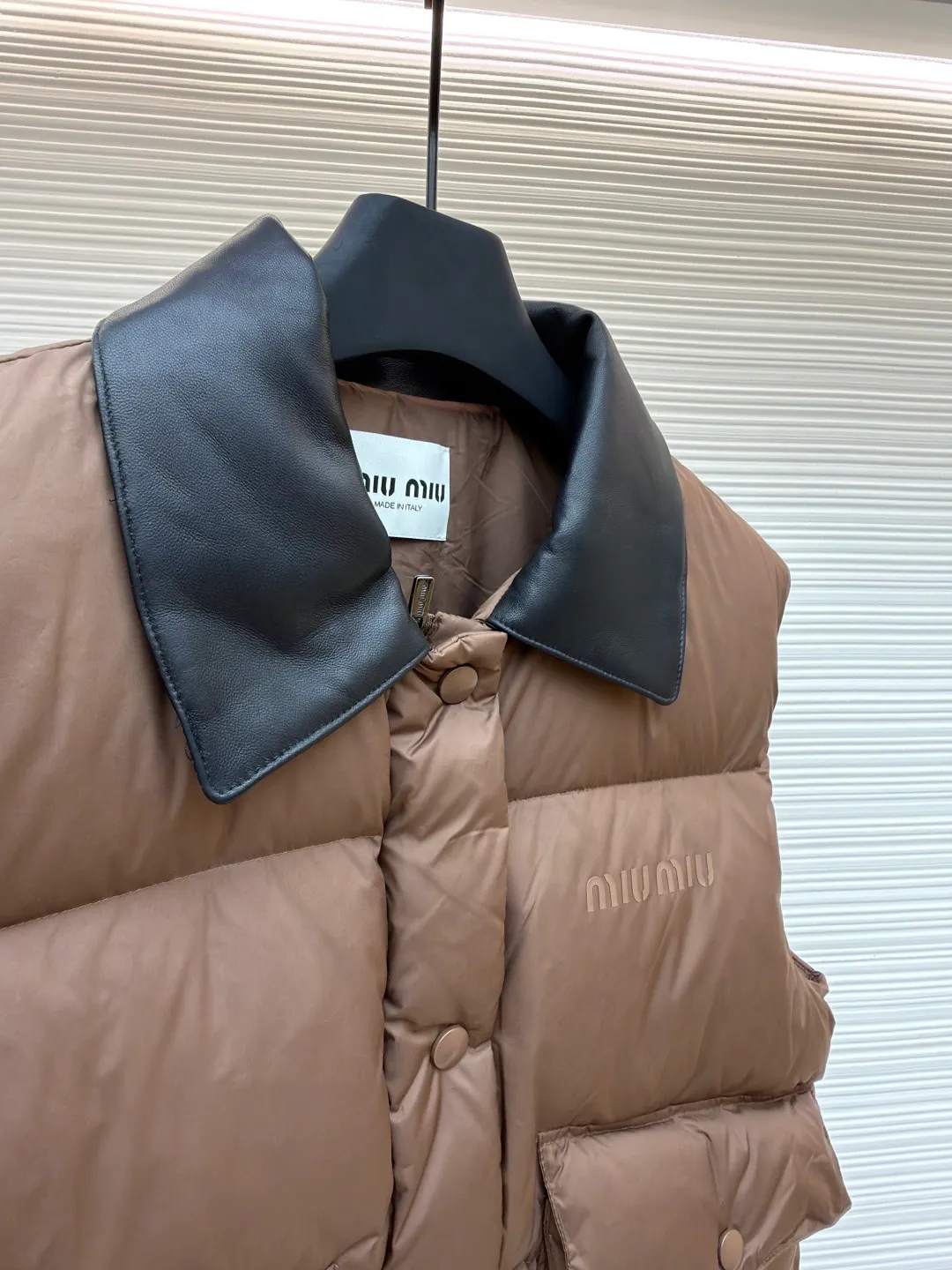 MIUMIU technology ponge down vest [Women's clothing] ●Item number: 1681115-C65 ●Material: white duck down fabric ●Technology: glue printing ●Version: fitted version ●Weight: about 425 grams ●Size: S-M-L ●Description: This vest is made of lightweight and durable nylon fabric with down filling, taking into account both warmth and fashion. The collar is made of genuine leather to enhance the overall texture and warmth. The outer layer of high-density nylon is windproof and waterproof, light and wear-resistant, and the inner layer is filled with down, which has high fluffiness and strong warmth retention. It is made of national standard 90 white duck down and has a filling capacity of 190 grams to ensure excellent warmth retention. The down has been strictly screened and processed and is not easy to be drilled, ensuring durability. The letter pattern is displayed on the breast bag piece through glue printing. The printer scrapes the print 10 times to ensure the printing thickness, forming a micro-three-dimensional convex structure. The scraper pressure is even and the firmness is improved. After being cured at high temperature, the pigment is combined with the fabric fibers and is not easy to fall off due to friction. The overall wiring is straight and delicate, the fabric is comfortable and soft, and the color is consistent without color difference. It can be matched with the same style to create a fashionable look and control various occasions. Customized accessories, complete with three standards, same style for men and women!