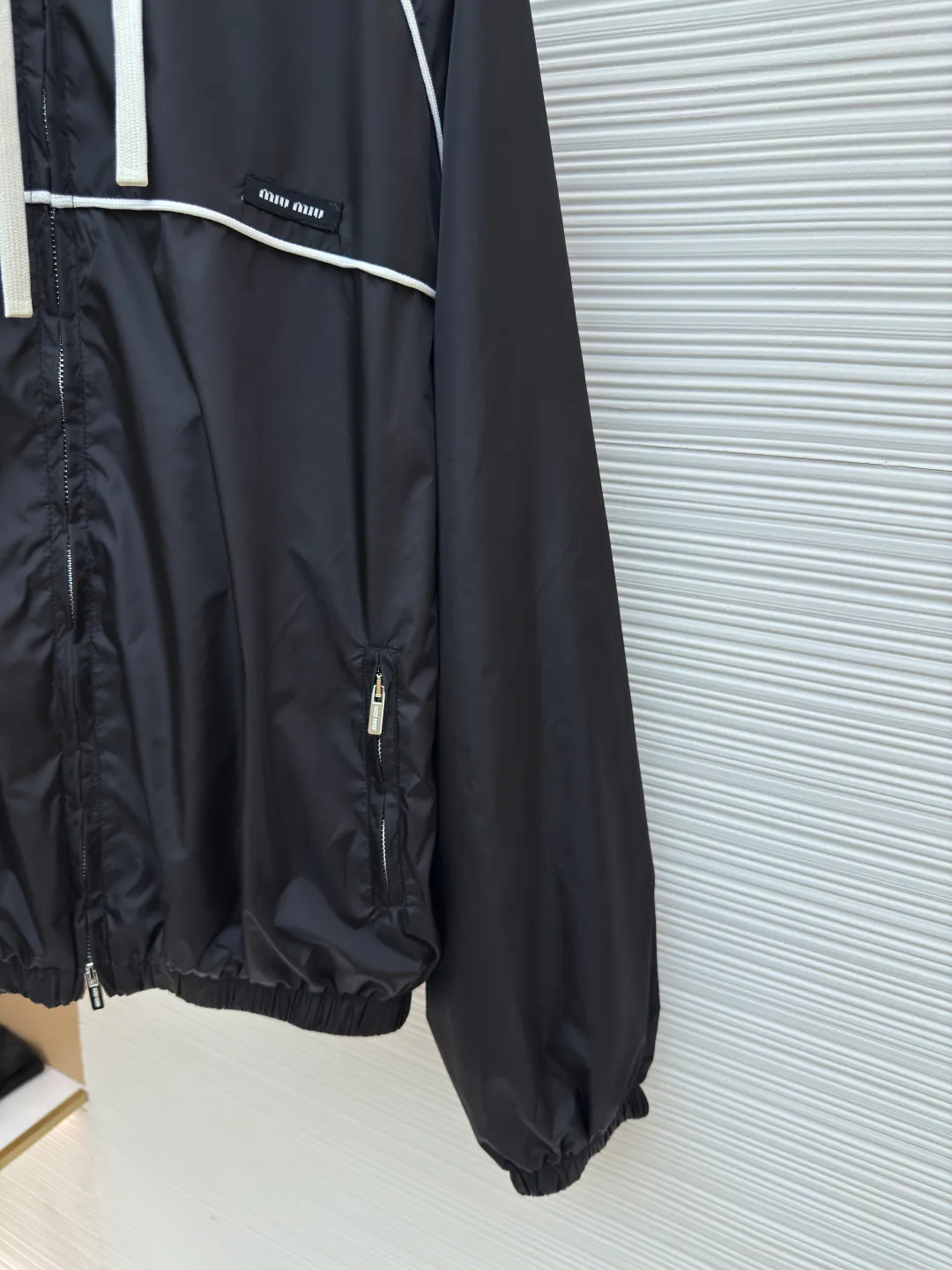 MIU MIU zipper hooded jacket ●Authentic product: Purchased and developed by 18999 ●Item number: 1680500-B40 ●Fabric: nylon fabric ●Technology: Positioning cutting machine ●Version: Fitted version ●Weight: about 420 grams ●Size: 36-38-40-42 ●Description: Customized cold-extraction smart hole fiber nylon worsted fabric, thin and delicate, comfortable and skin-friendly, with classic black as the main color The ultimate fusion of depth and elegance. The eye-catching miumiu logo patch is embellished on the chest, showing the brand's consistent sophistication and elegance. The lightly dancing hood creates a lazy and casual atmosphere. The carefully outlined white piping is the finishing touch, achieving perfect visual balance in harmony. The leader of fashion trends, the overall line is straight and delicate, the fabric is comfortable and soft, and the color is consistent without color difference. It can be matched with the same style to create a fashionable look, and can be used in various occasions. Customized accessories, complete with three standards, same style for men and women!